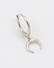 A silver-colored hoop earring with a hinged clasp and a small crescent moon charm attached to it.