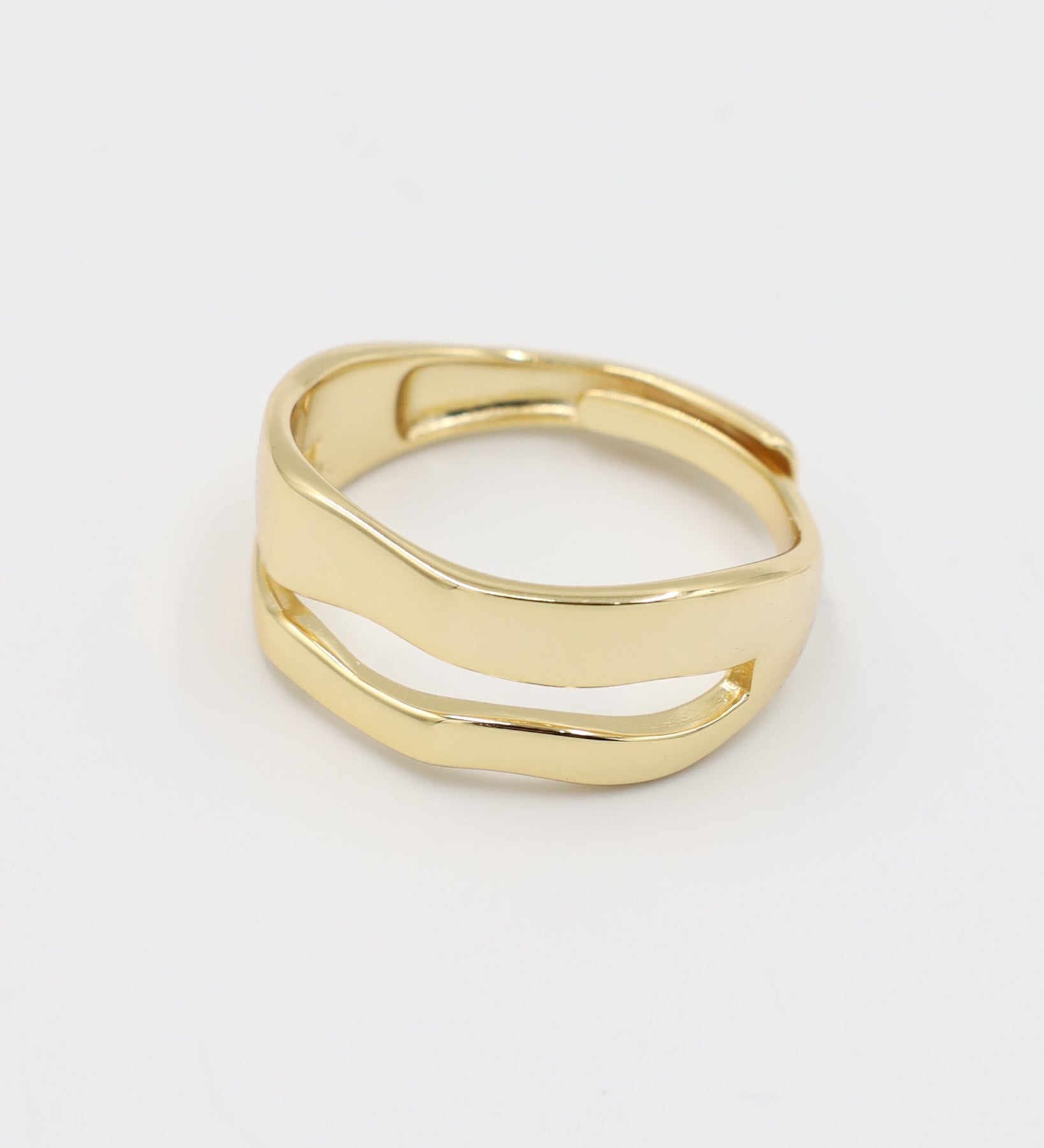 A single gold-colored ring with a smooth, curved design on a white background.