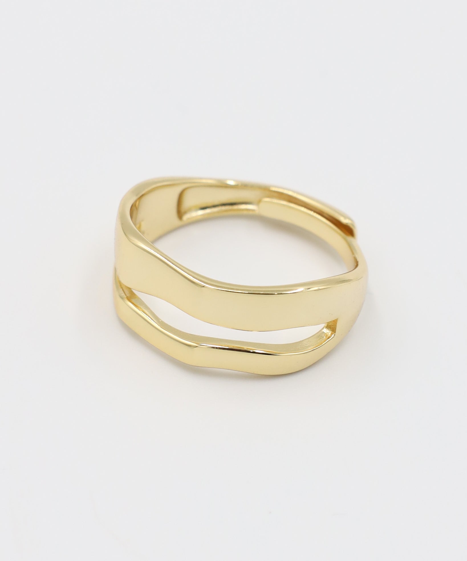 A single gold-colored ring with a smooth, curved design on a white background.