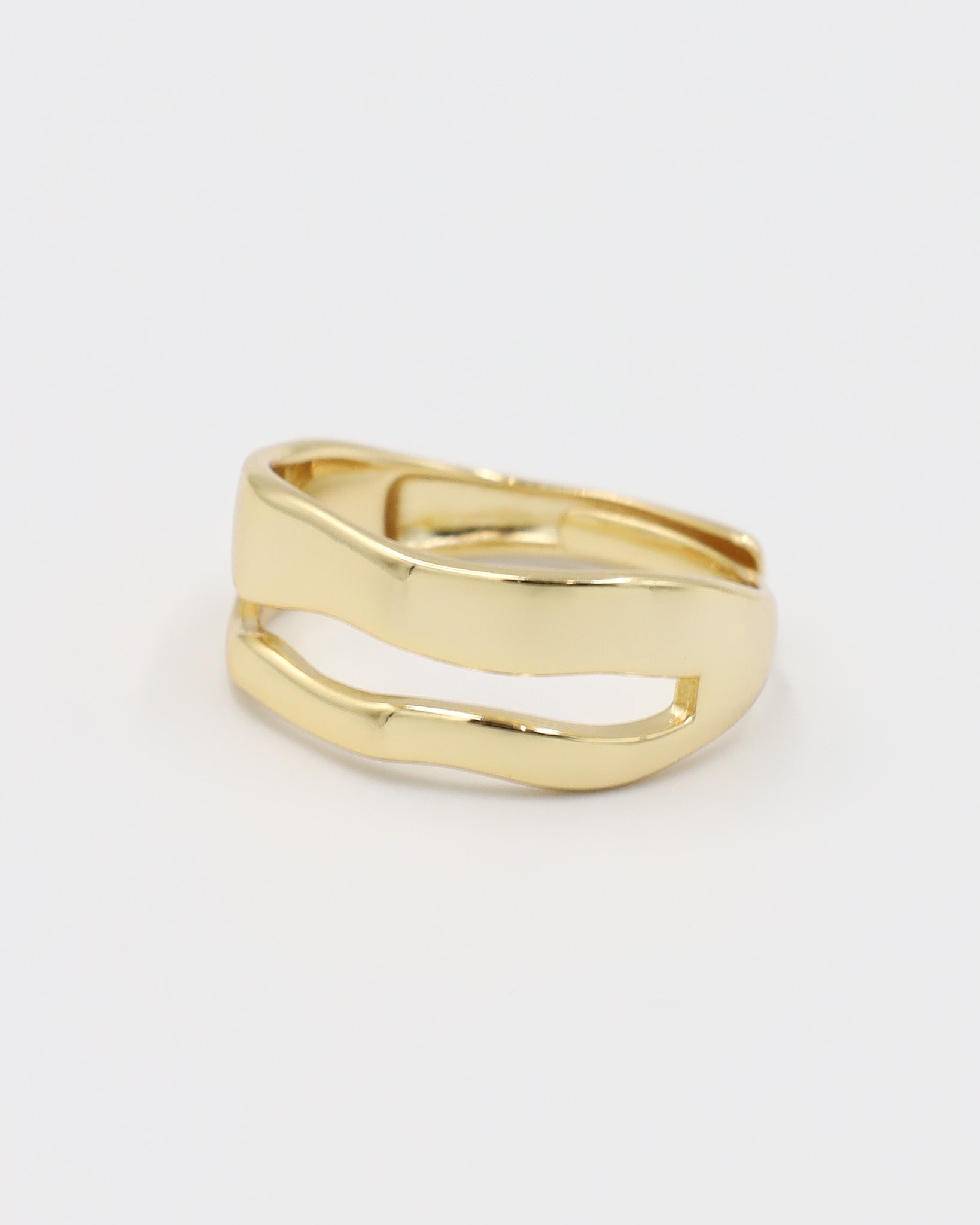 A single gold-colored ring with a smooth, curved design on a white background.