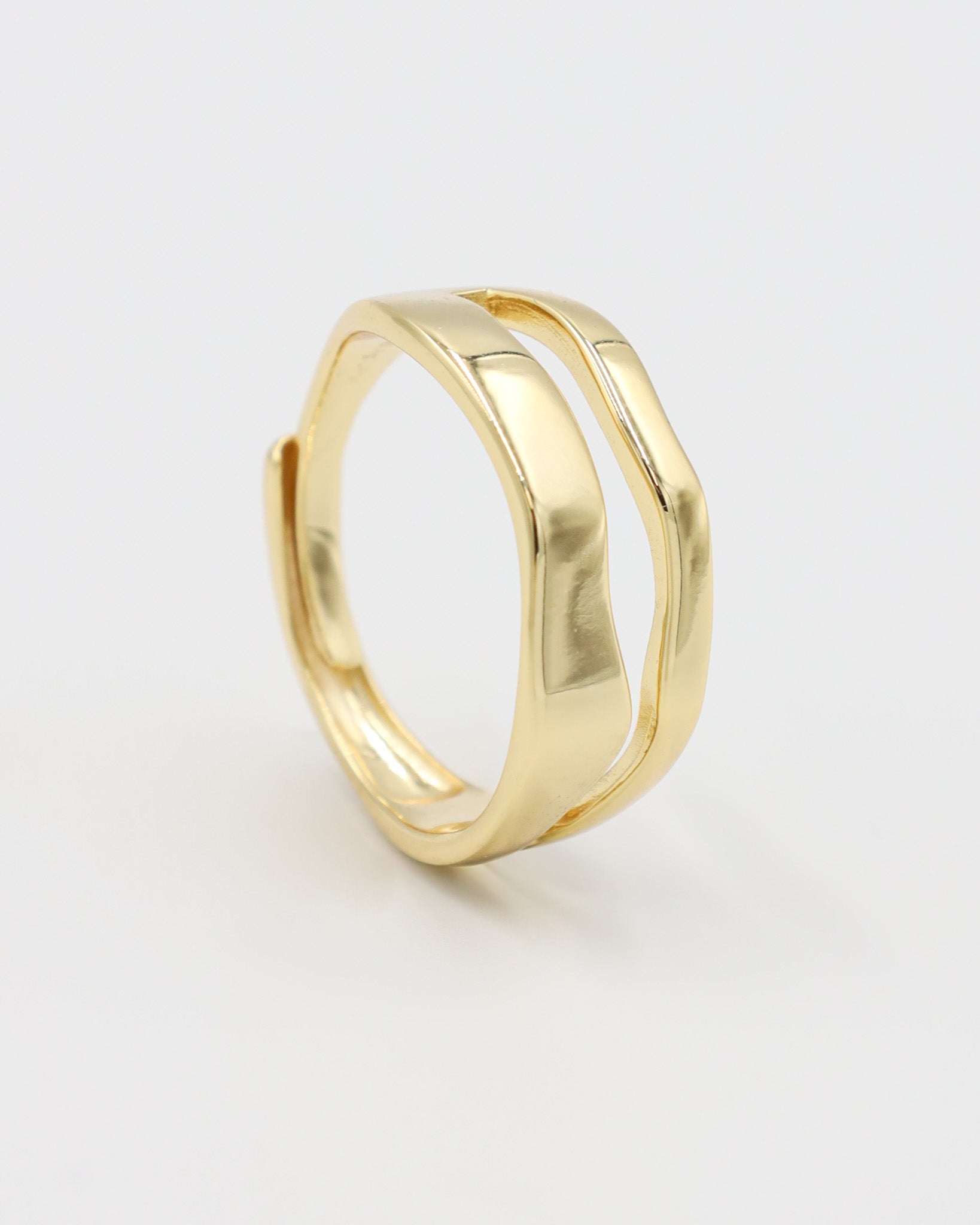 A single gold-colored ring with a smooth, curved design on a white background.