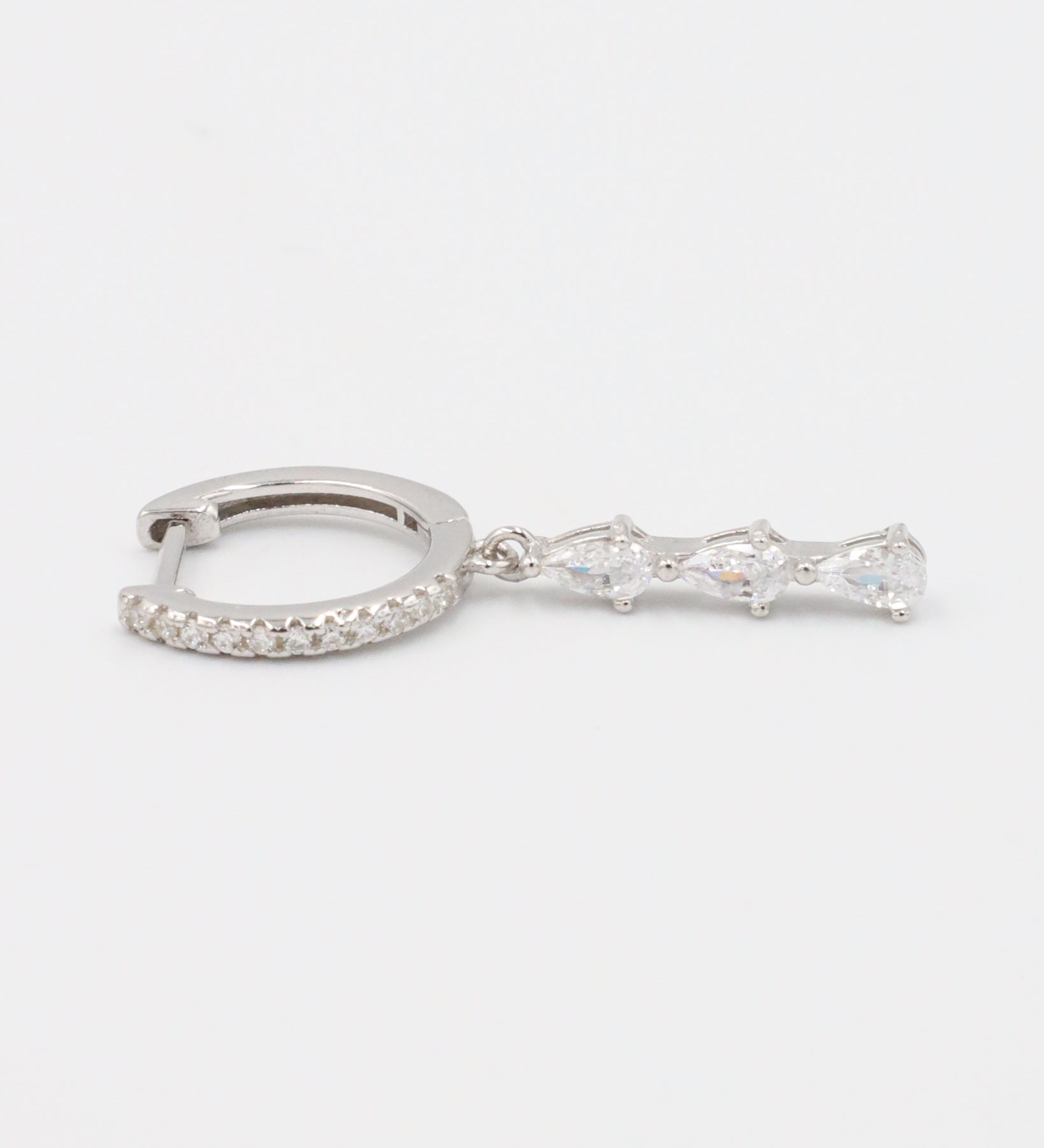 Single sterling silver drop earring with teardrop-shaped cubic zirconia stones, showcasing a sleek and elegant look.