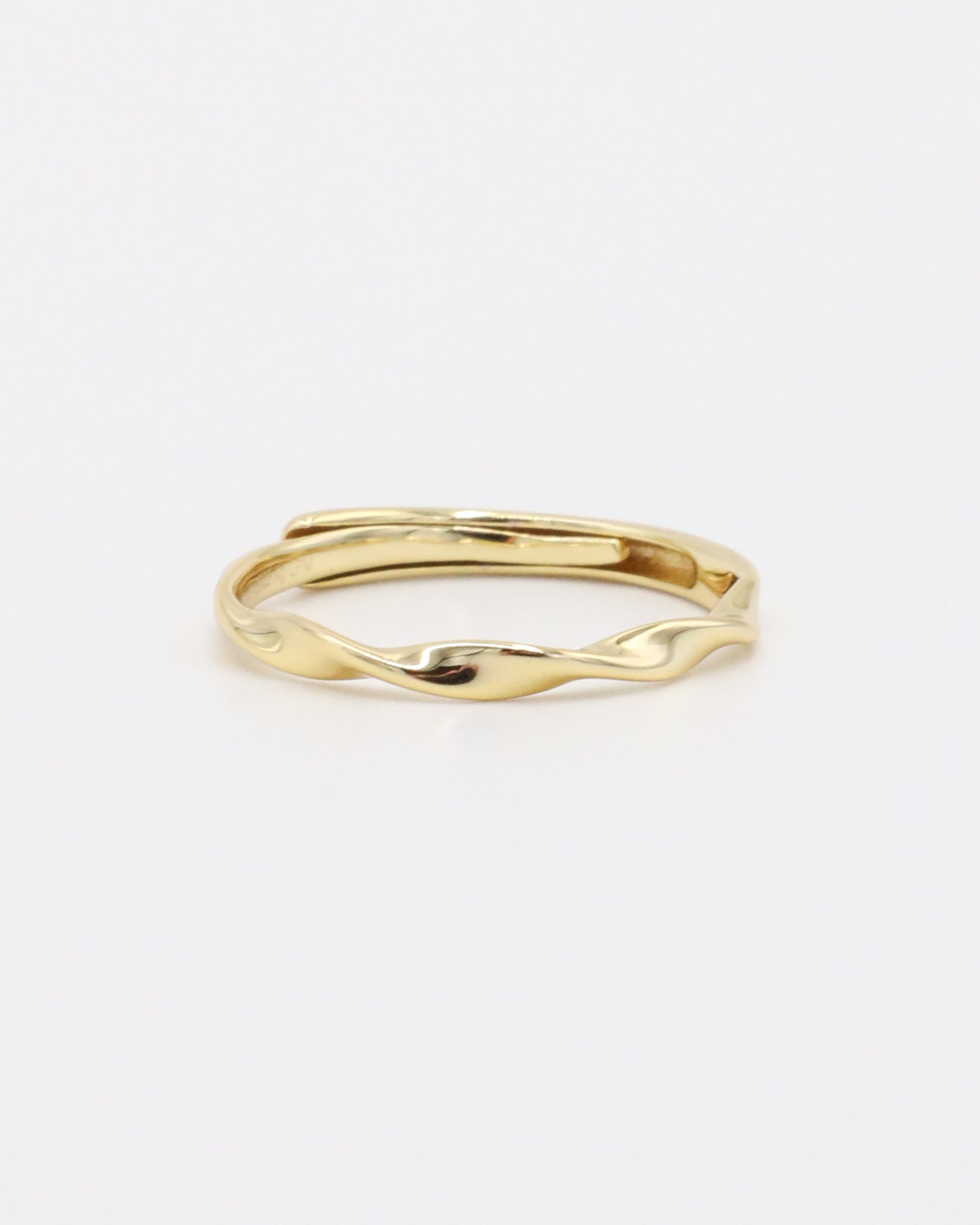 A gold-colored band ring with a textured surface on a white background.