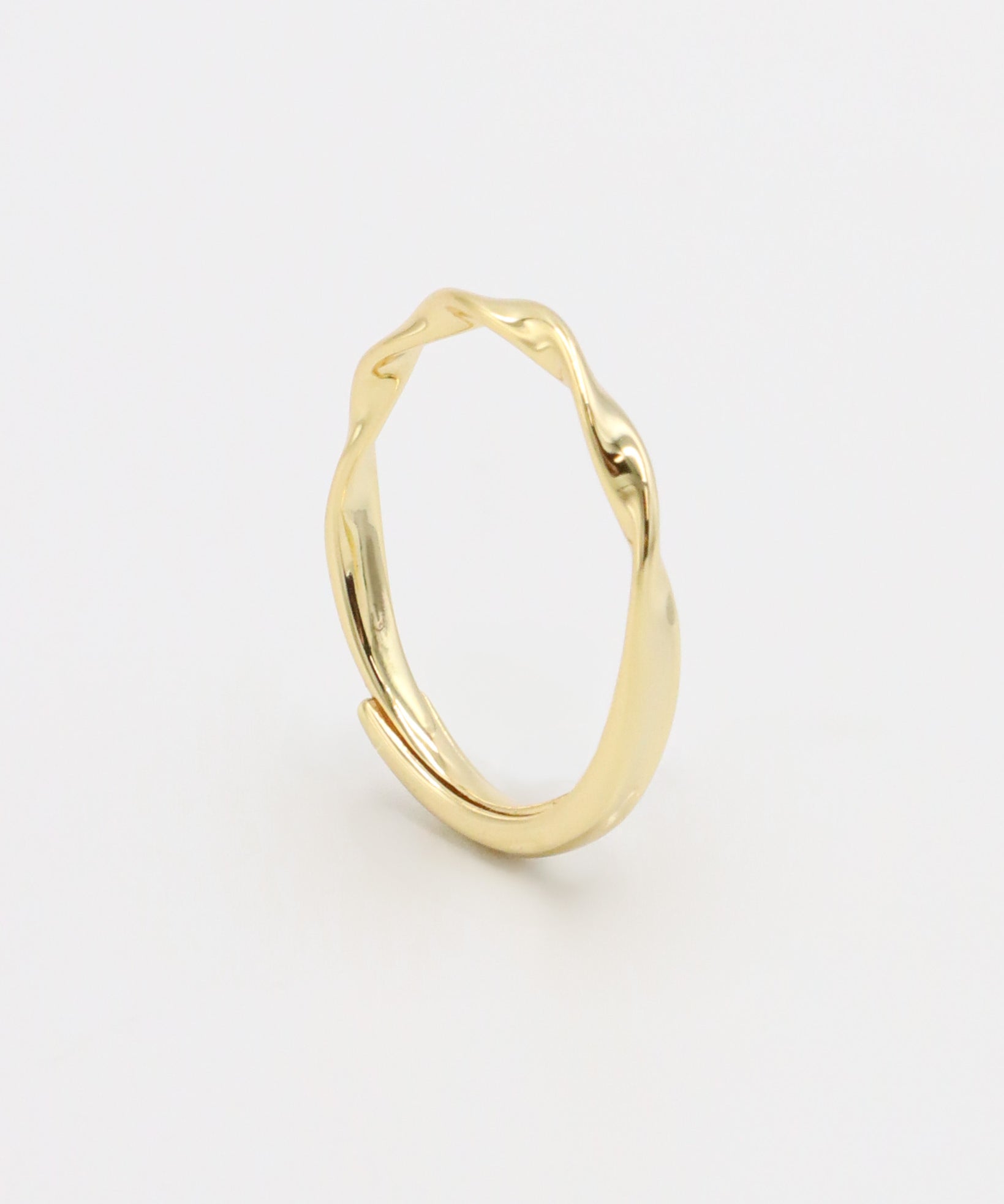 A gold-colored band ring with a textured surface on a white background.