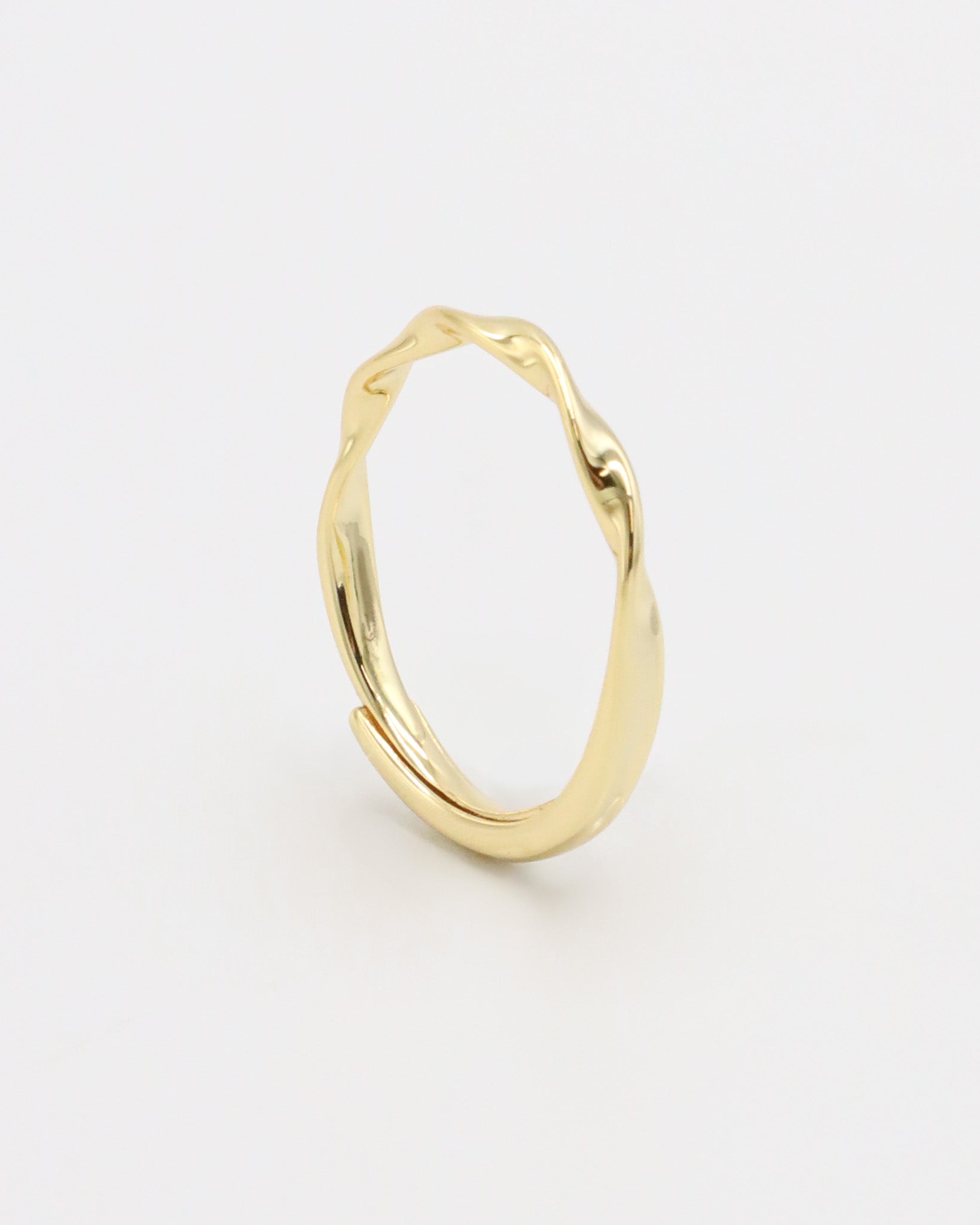 A gold-colored band ring with a textured surface on a white background.