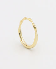 A gold-colored band ring with a textured surface on a white background.