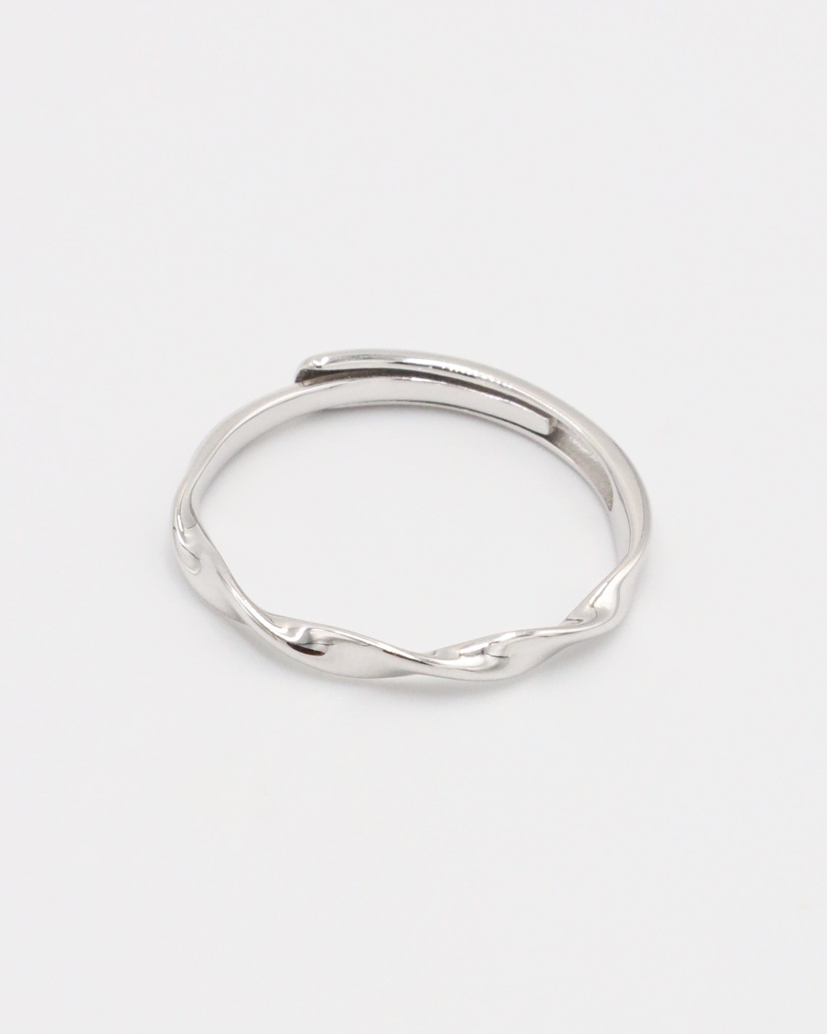 A silver ring with a simple, modern design displayed against a white background.