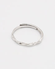 A silver ring with a simple, modern design displayed against a white background.