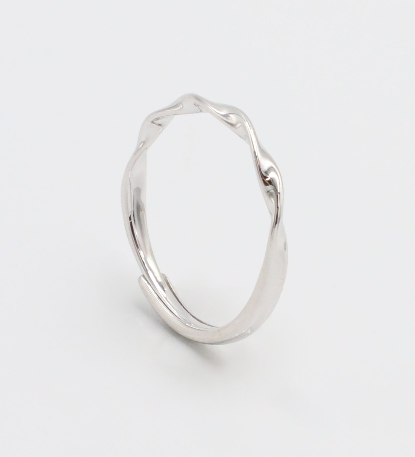 A silver ring with a simple, modern design displayed against a white background.