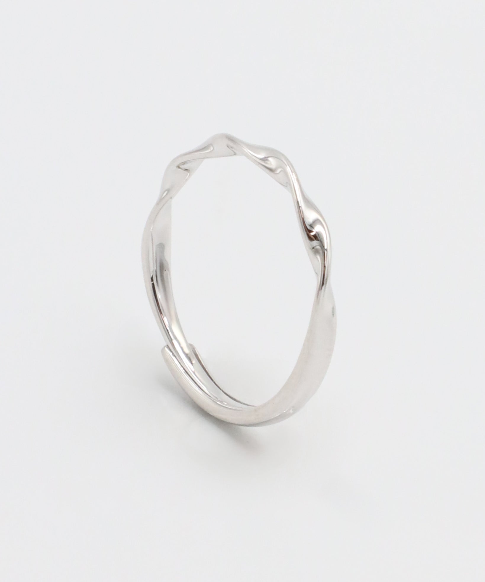 A silver ring with a simple, modern design displayed against a white background.