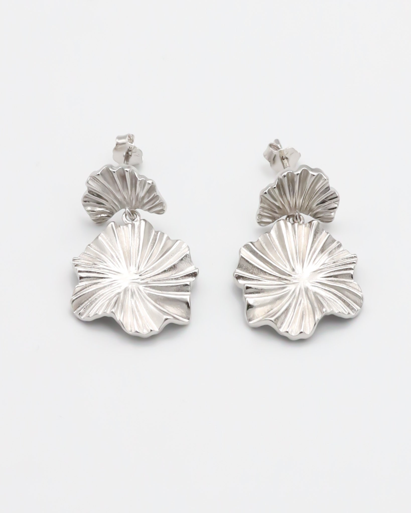 A pair of silver stud earrings with a butterfly clasp and floral design