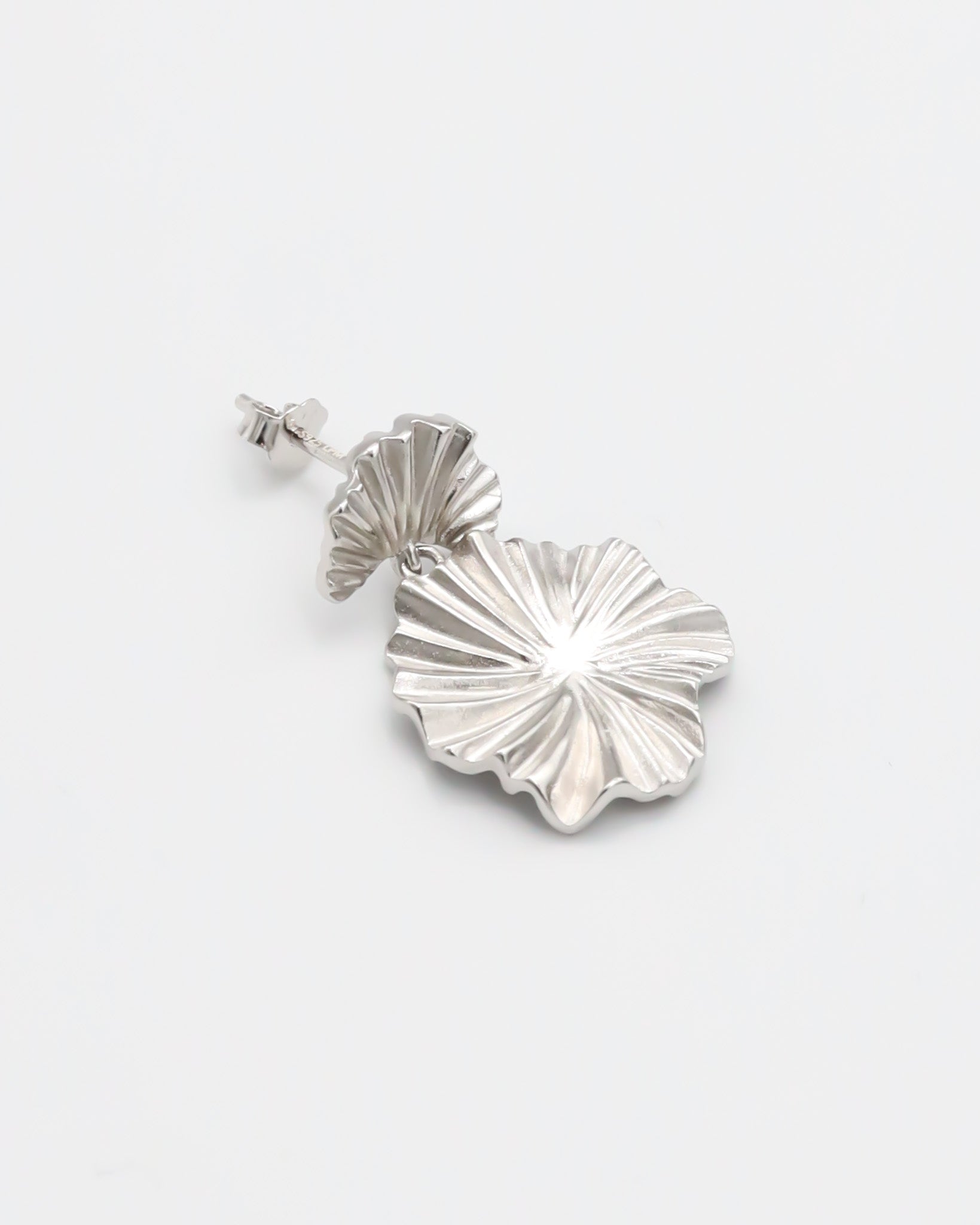 A single silver stud earring with a butterfly clasp and floral design