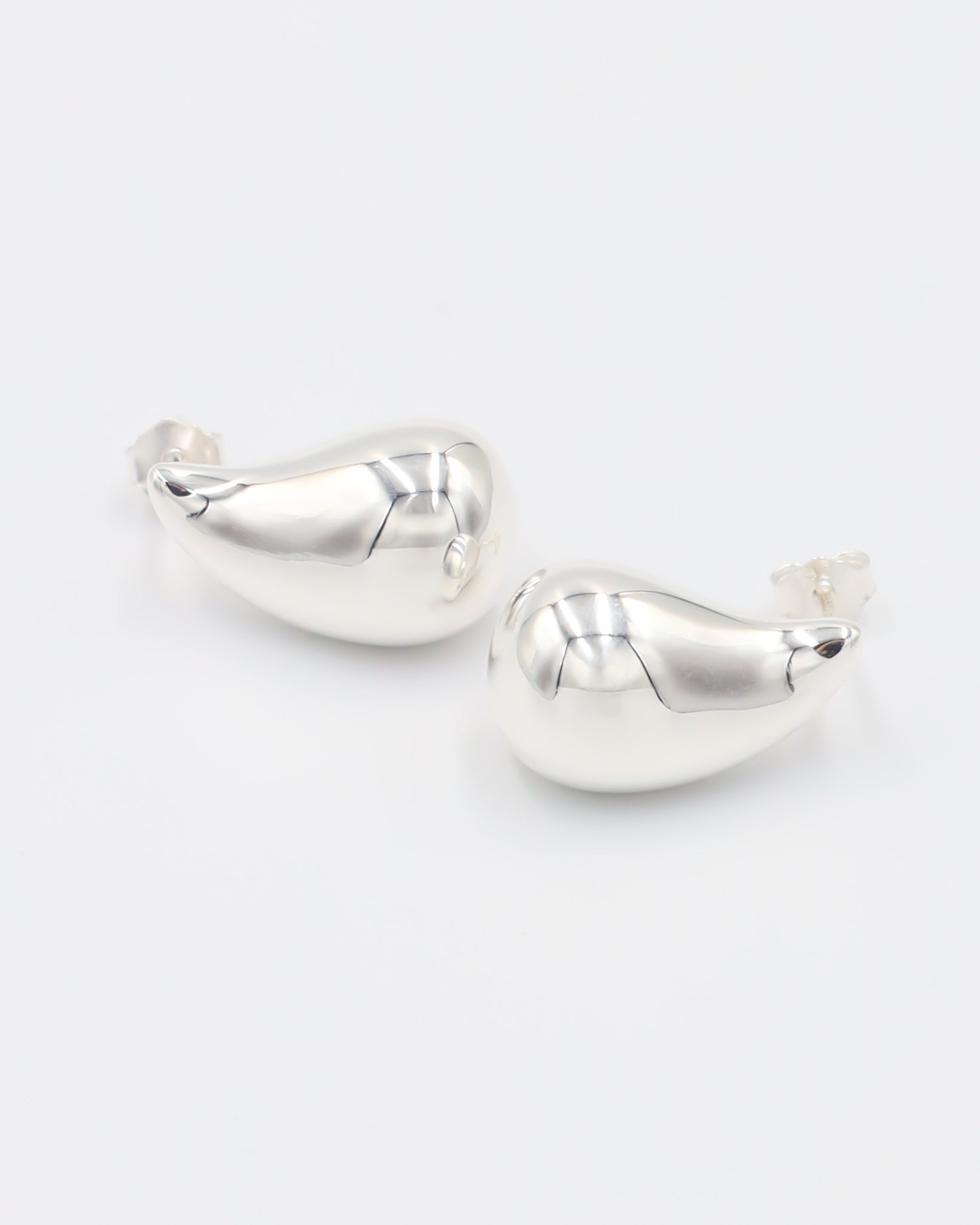 A pair of silver stud earrings with a butterfly clasp
