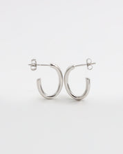 A pair of silver hoop earrings with a butterfly clasp closure on a white background.