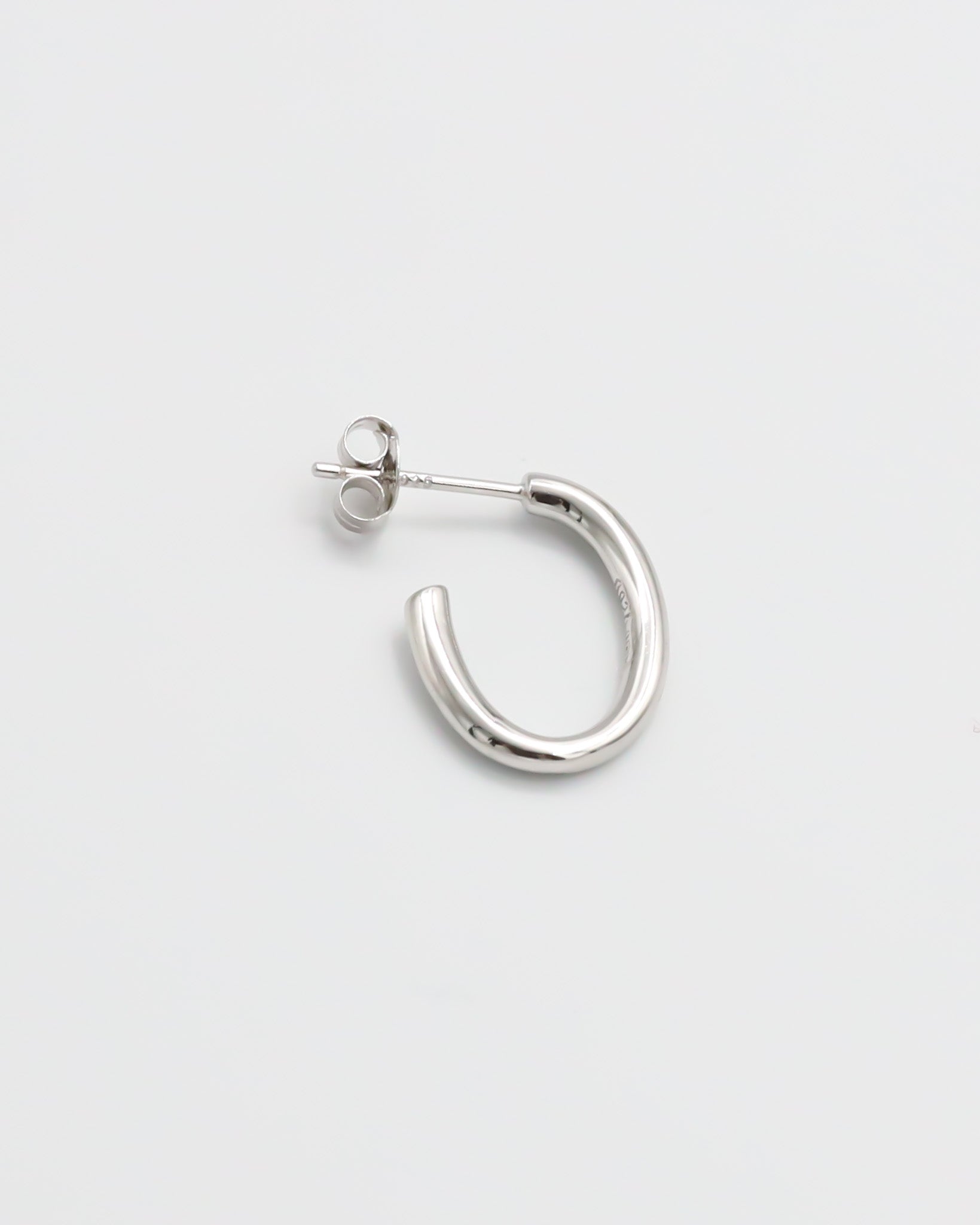 A pair of silver hoop earrings with a butterfly clasp closure on a white background.