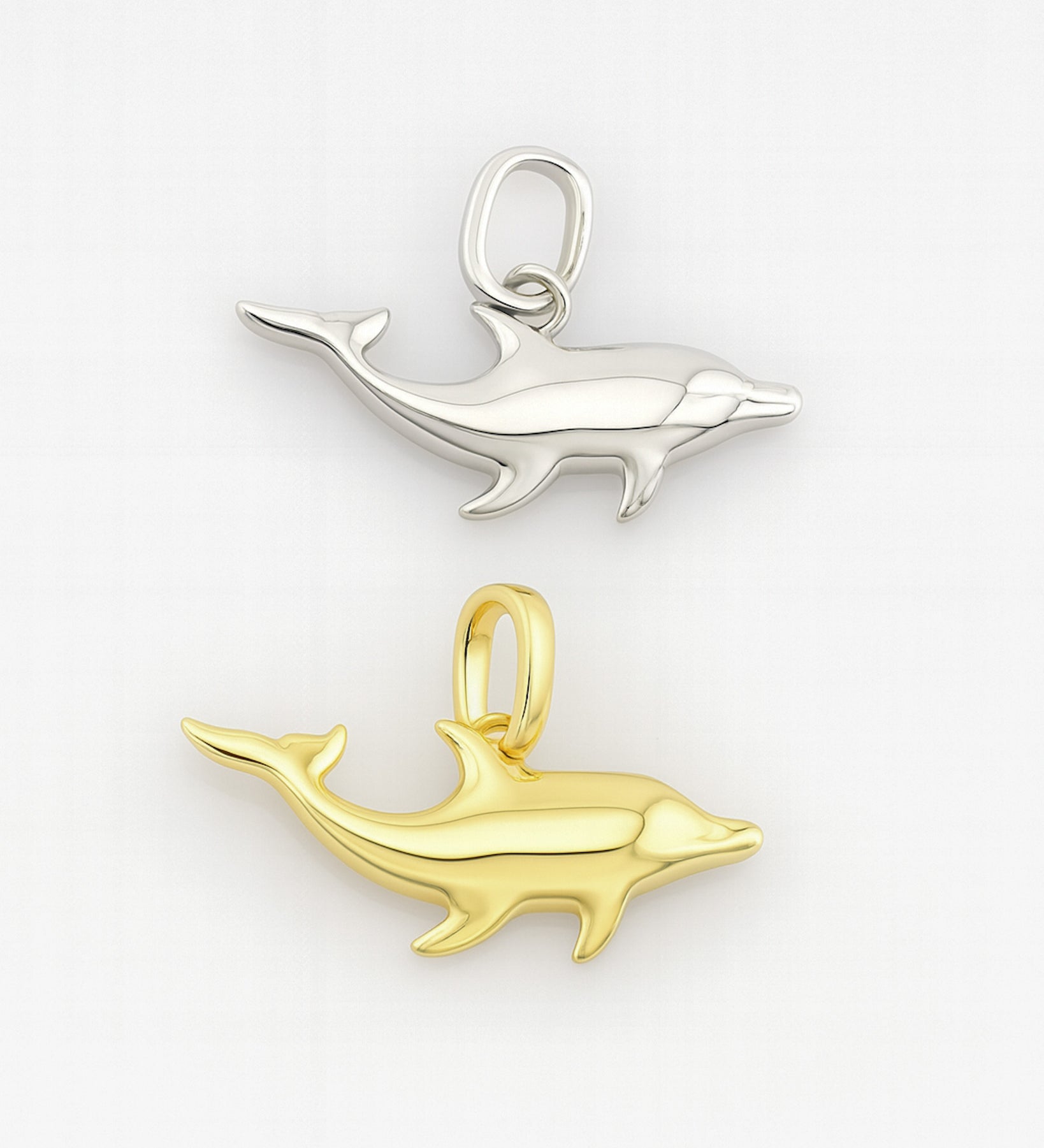 Gold and silver dolphin pendants on a white background