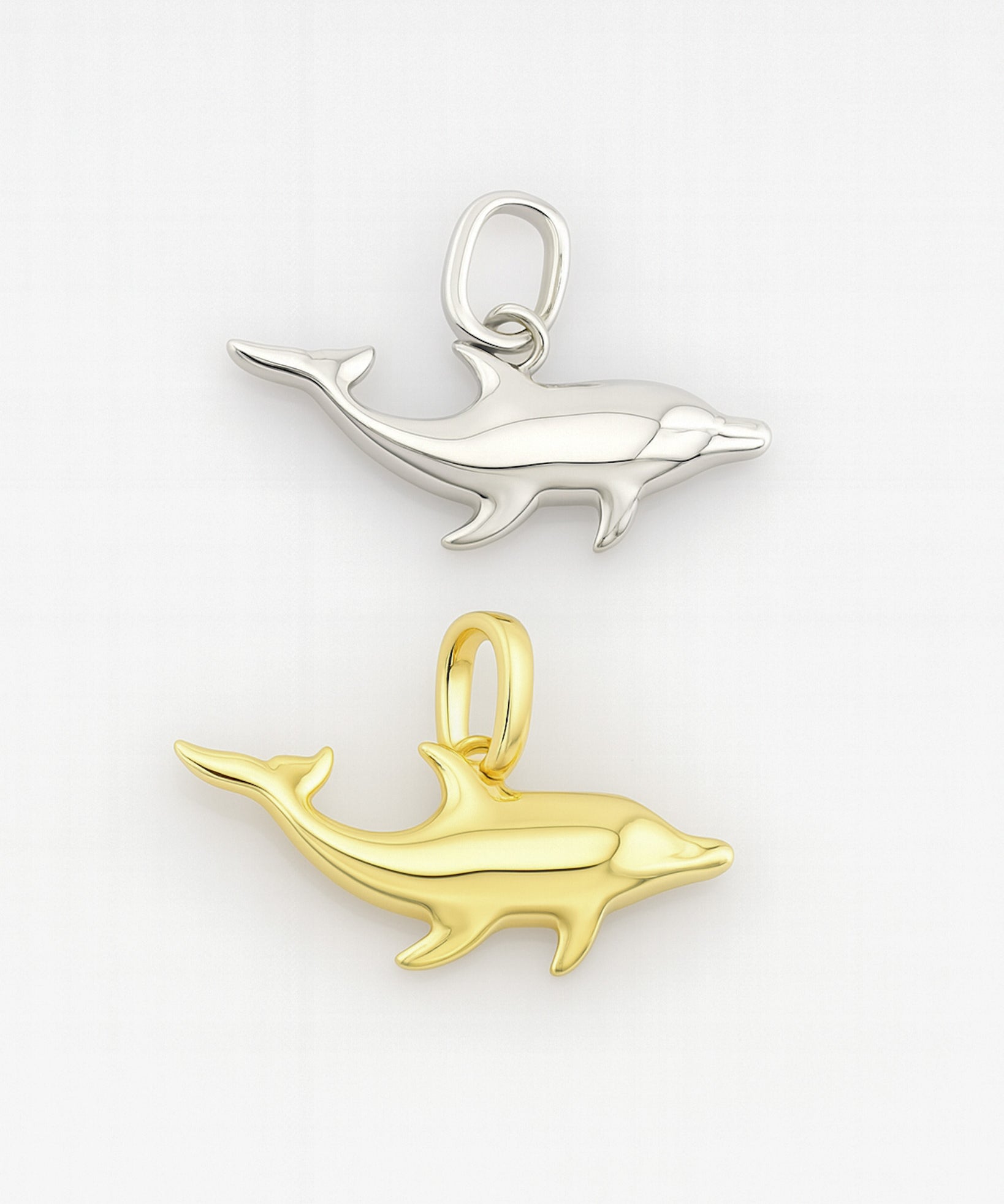 Gold and silver dolphin pendants on a white background