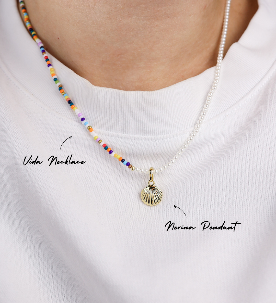 Necklace with colorful beads and a shell pendant on a white shirt