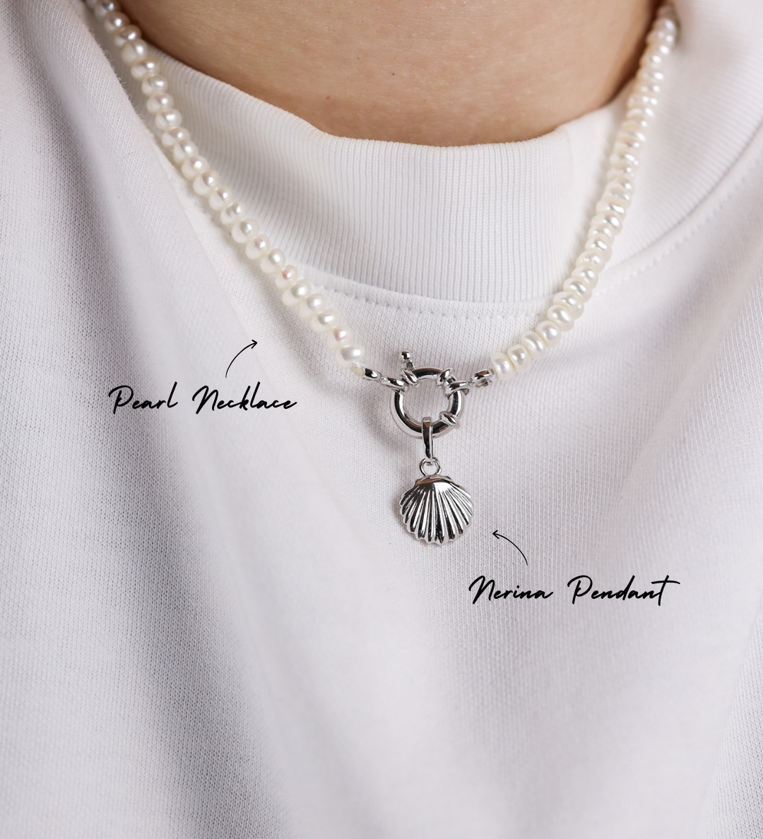 Pearl necklace with a silver pendant on a white shirt