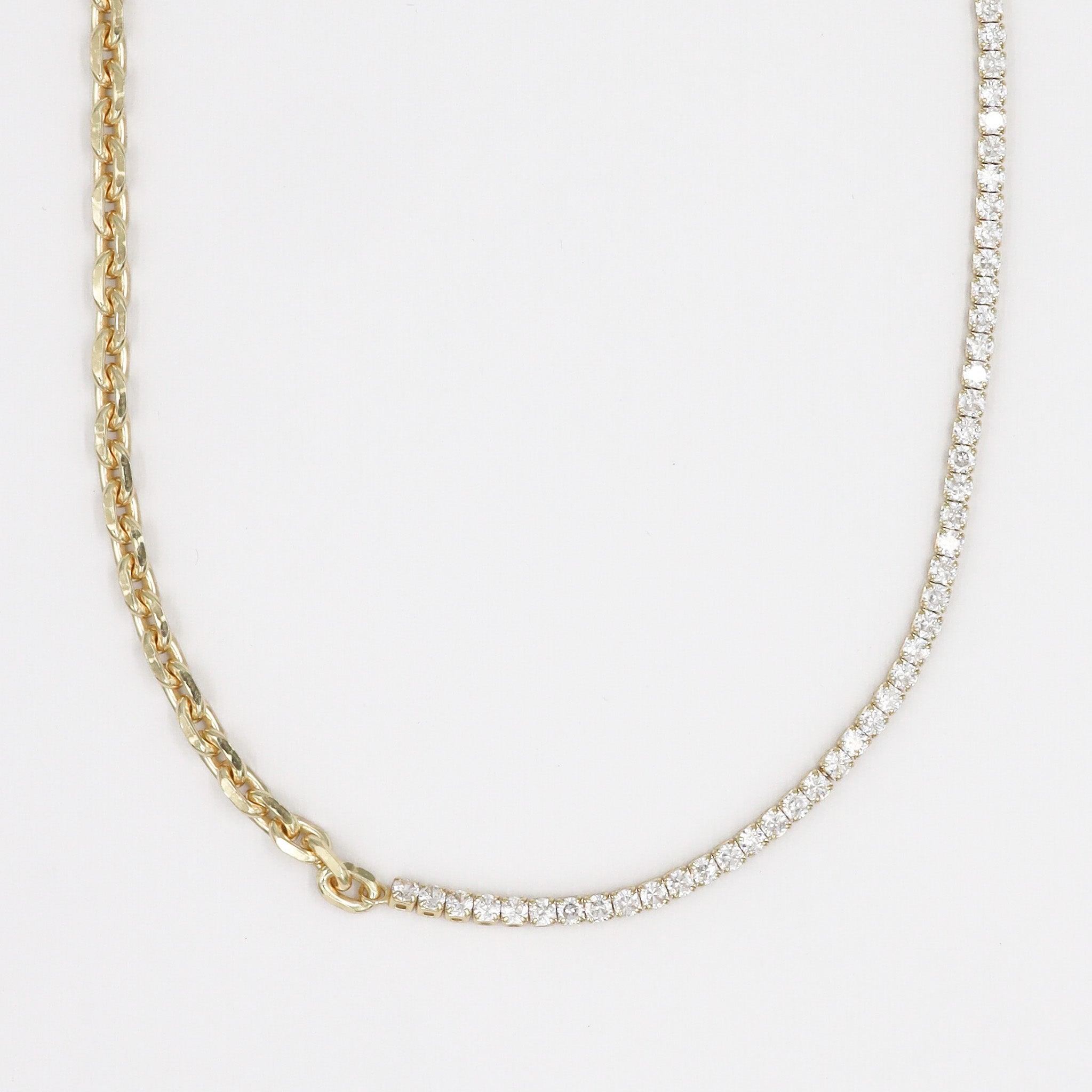 A gold-plated sterling silver necklace with a chain link design and adorned with small clear stones.