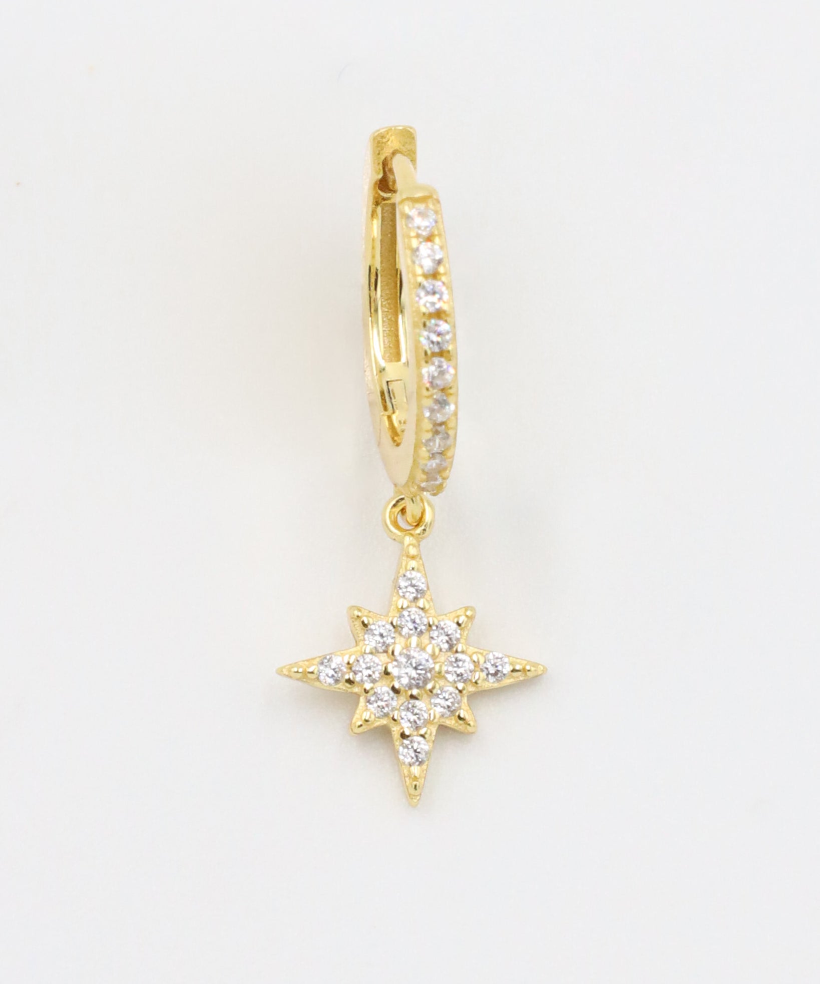 A single gold-plated sterling silver hoop earring with pavé zirconia stones and a star-shaped pendant, detailed with additional zirconia.