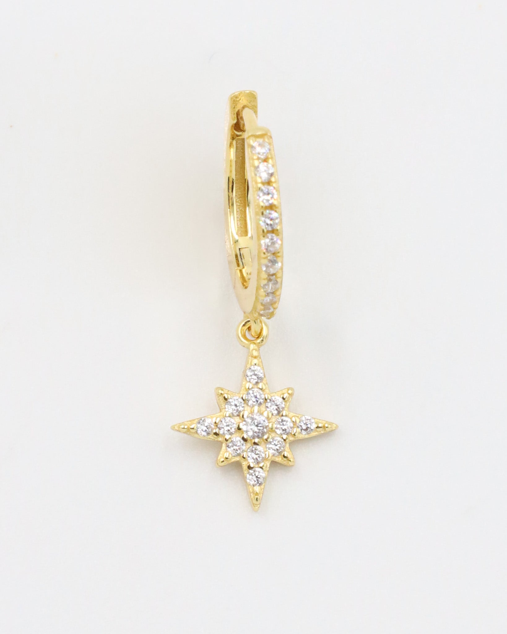 A single gold-plated sterling silver hoop earring with pavé zirconia stones and a star-shaped pendant, detailed with additional zirconia.