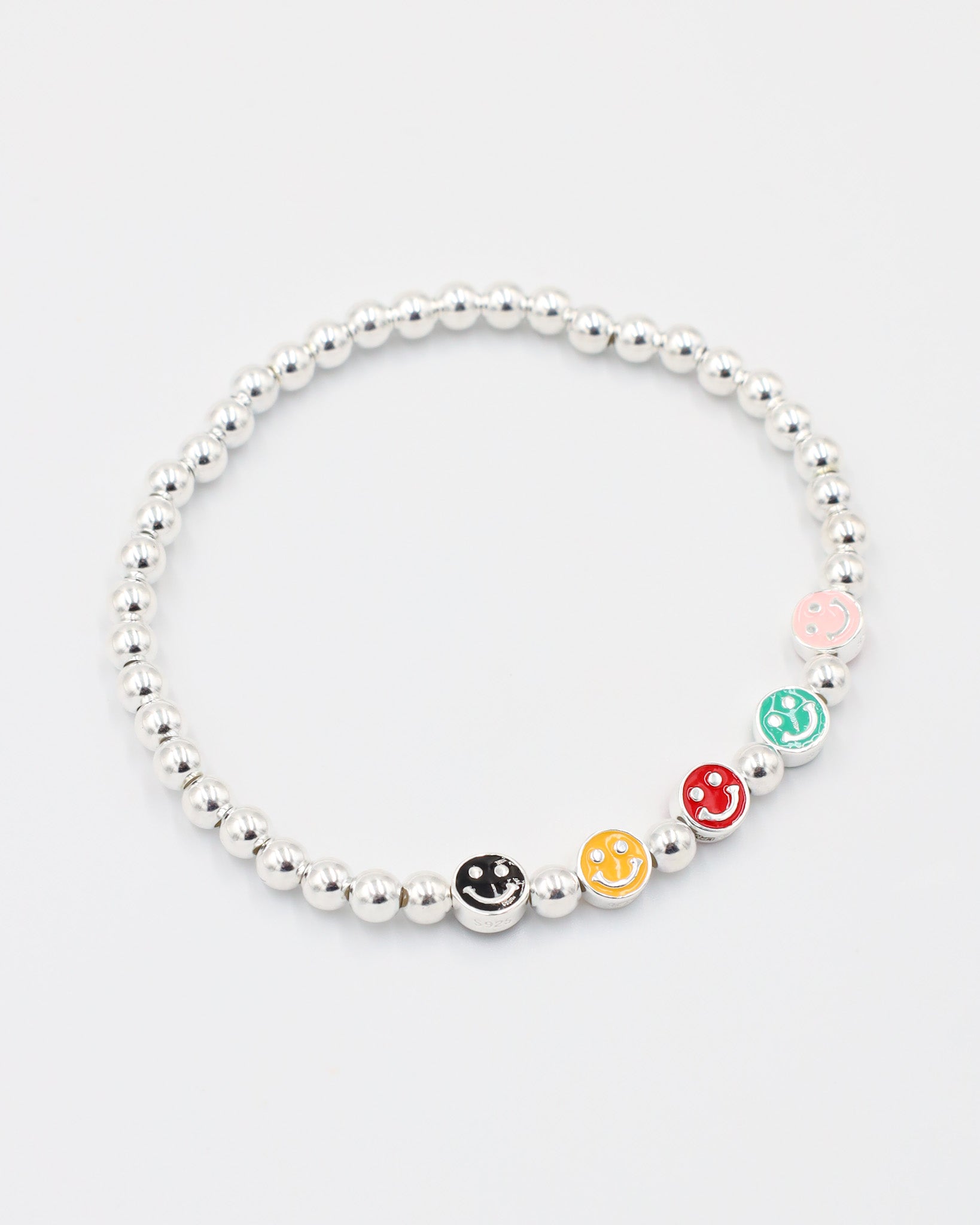 Side view of adjustable sterling silver bracelet with five colorful smiley face beads and silver beads.