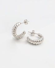 A pair of silver hoop earrings on a white background