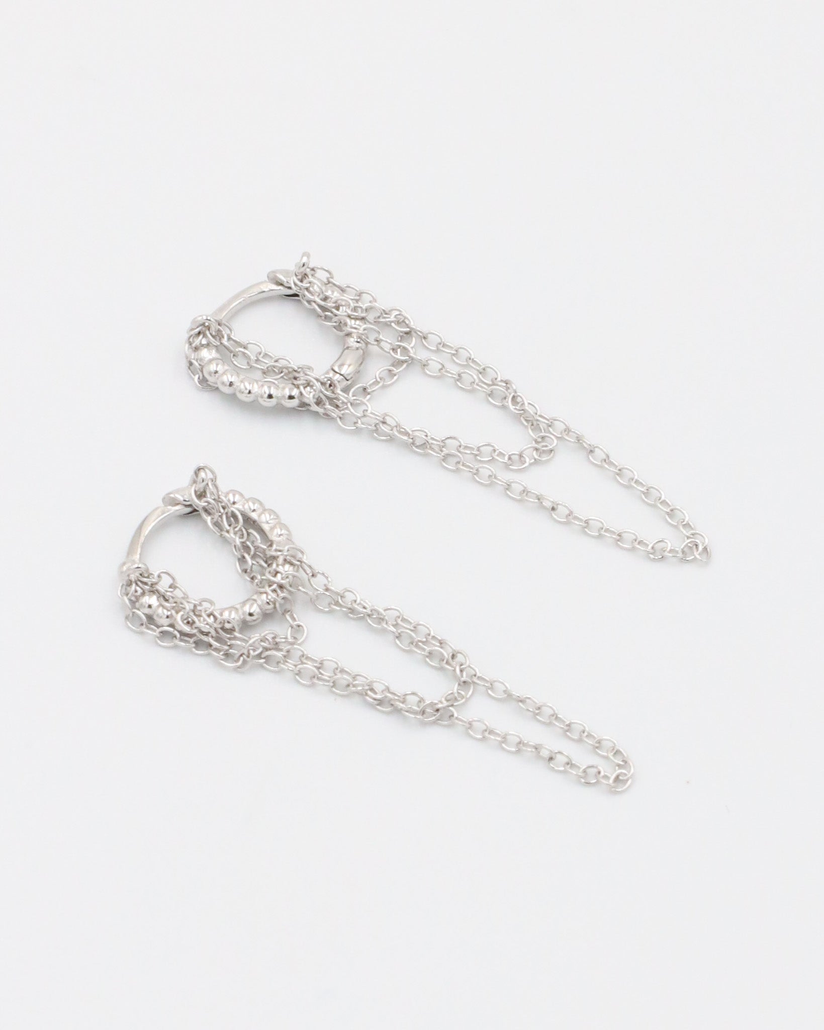 A pair of silver hoop earrings with a gold plated finish on a white background.