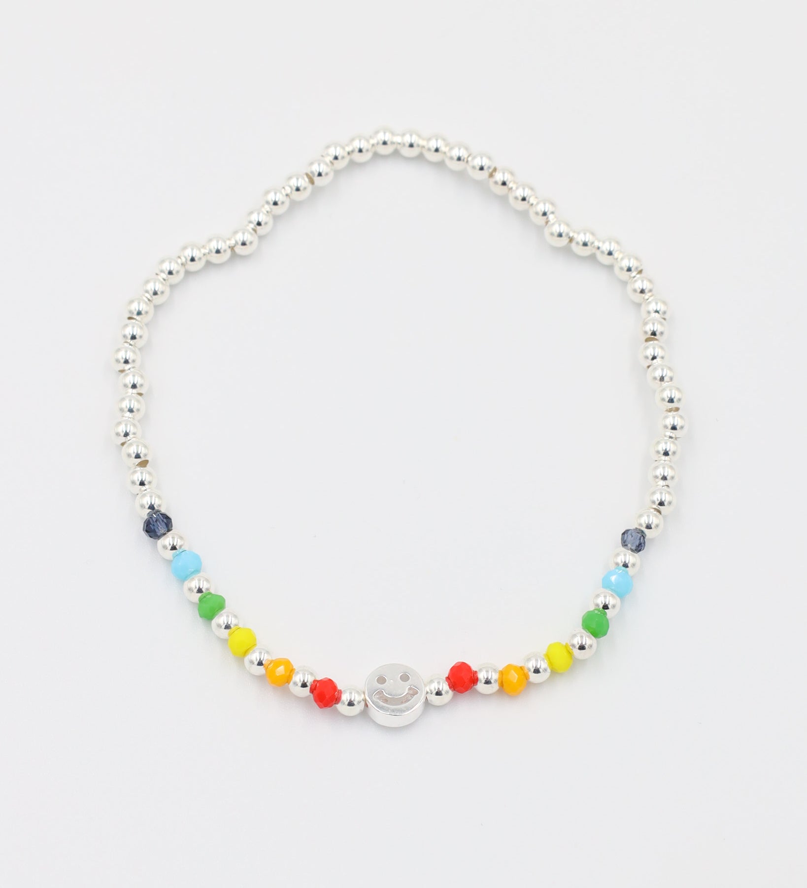 Adjustable sterling silver Pietro bracelet with a smiley charm, top view with colorful accent beads.