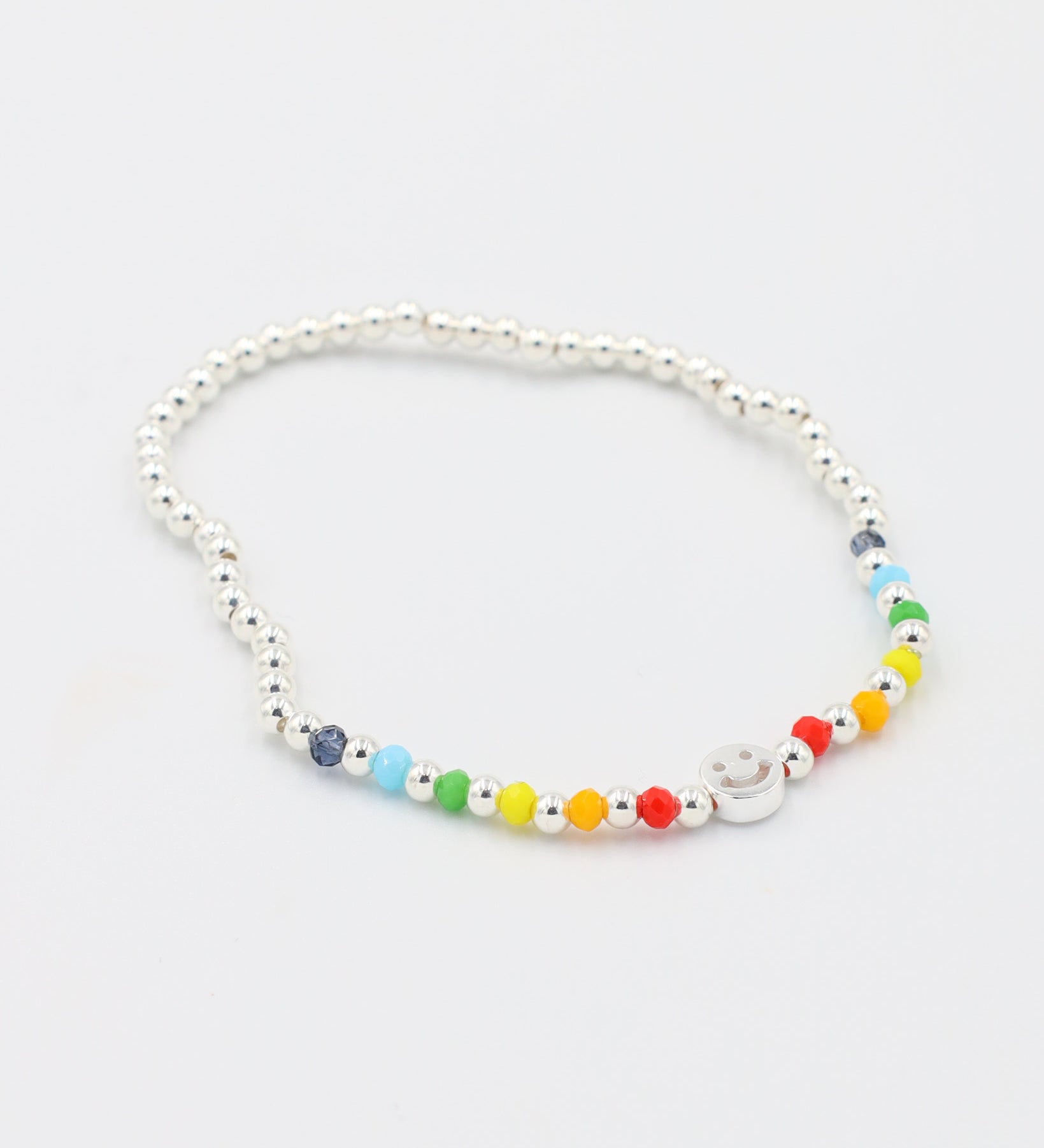 Adjustable sterling silver Pietro bracelet featuring a smiley charm and colorful accent beads, angled view.