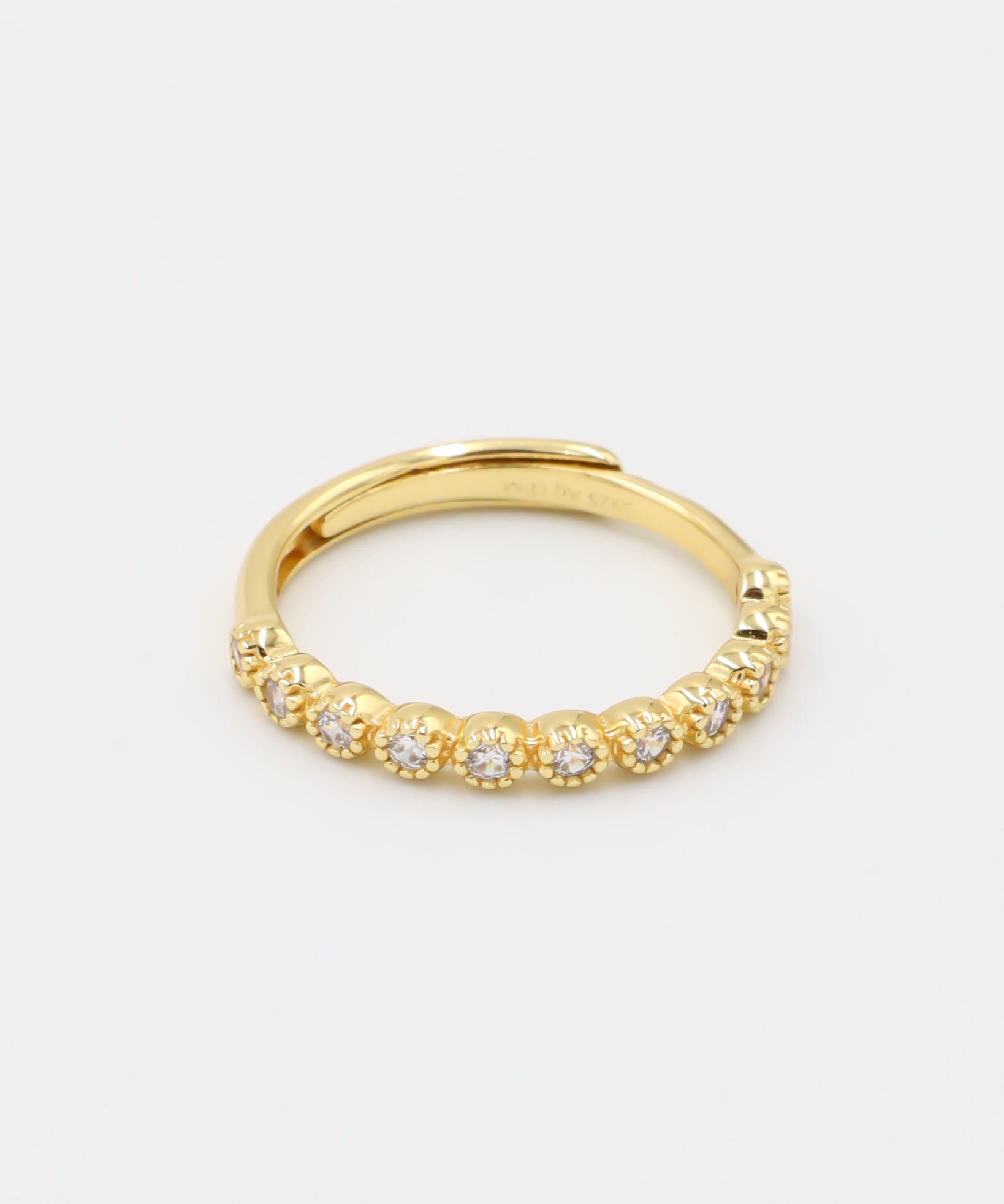 A gold-colored ring with multiple gemstones set around its circumference.