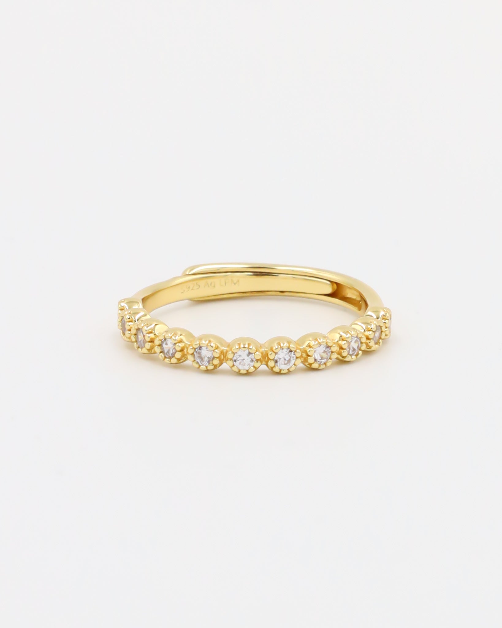 A gold-colored ring with multiple gemstones set around its circumference.