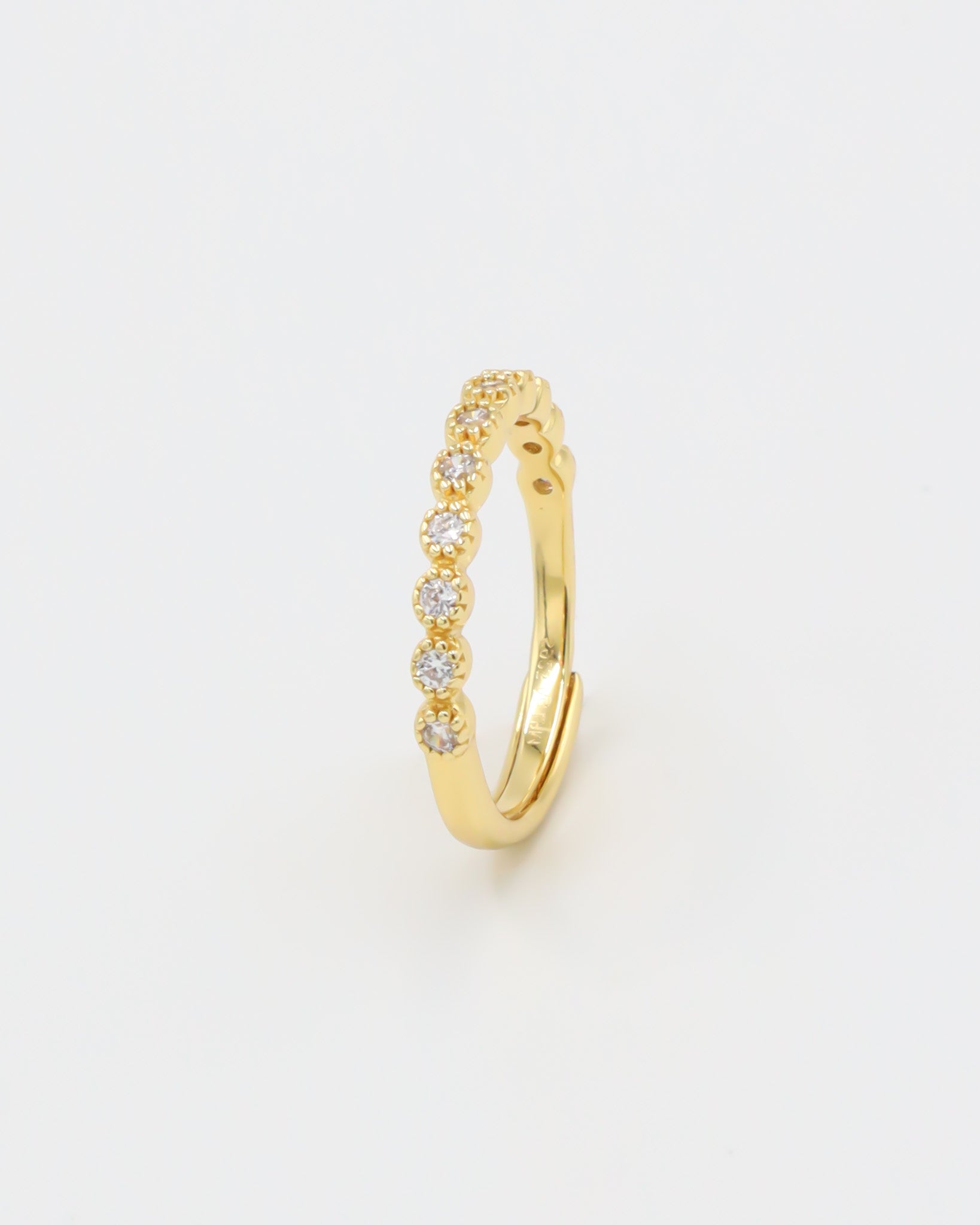 A gold-colored ring with multiple gemstones set around its circumference.