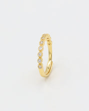 A gold-colored ring with multiple gemstones set around its circumference.