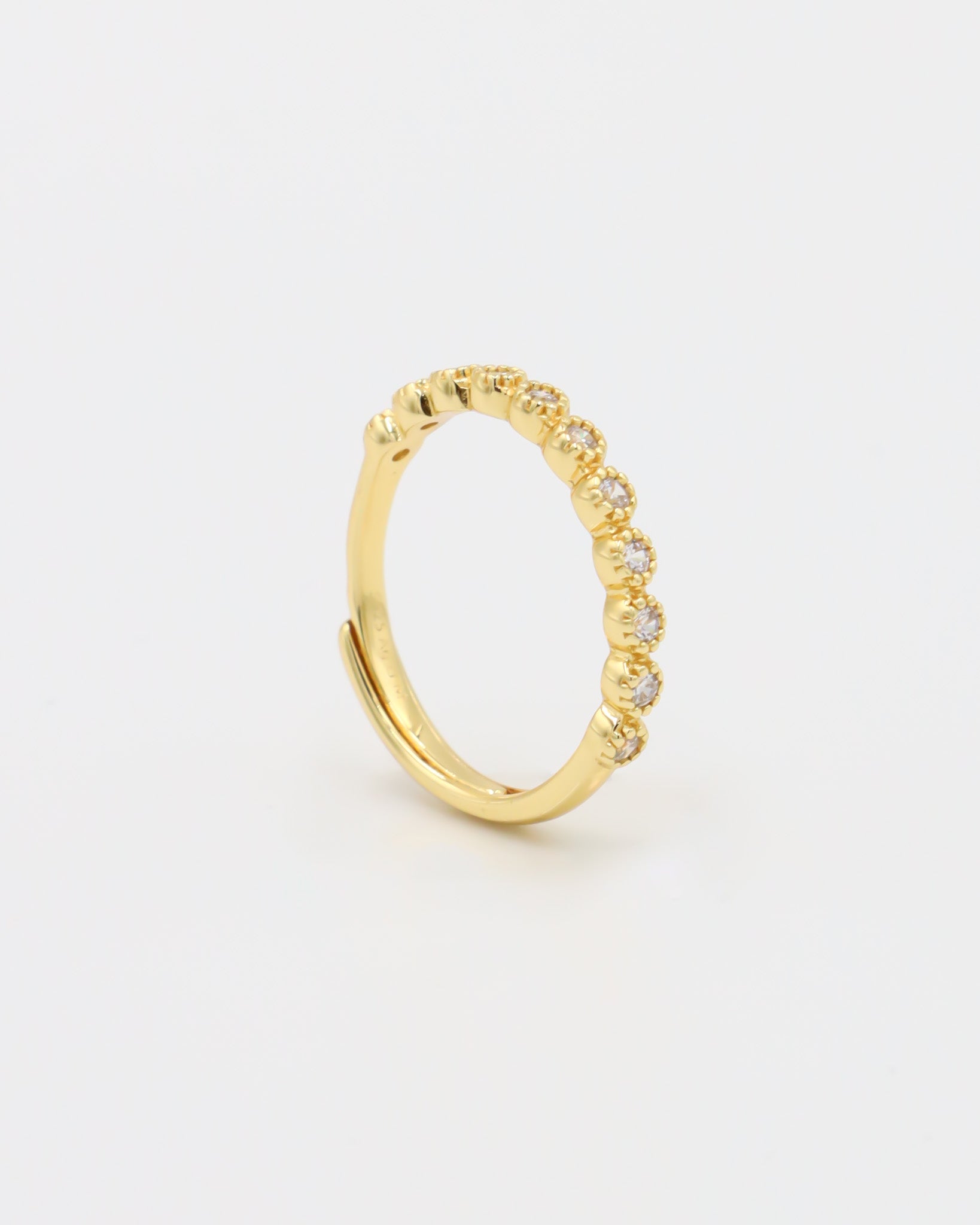 A gold-colored ring with multiple gemstones set around its circumference.