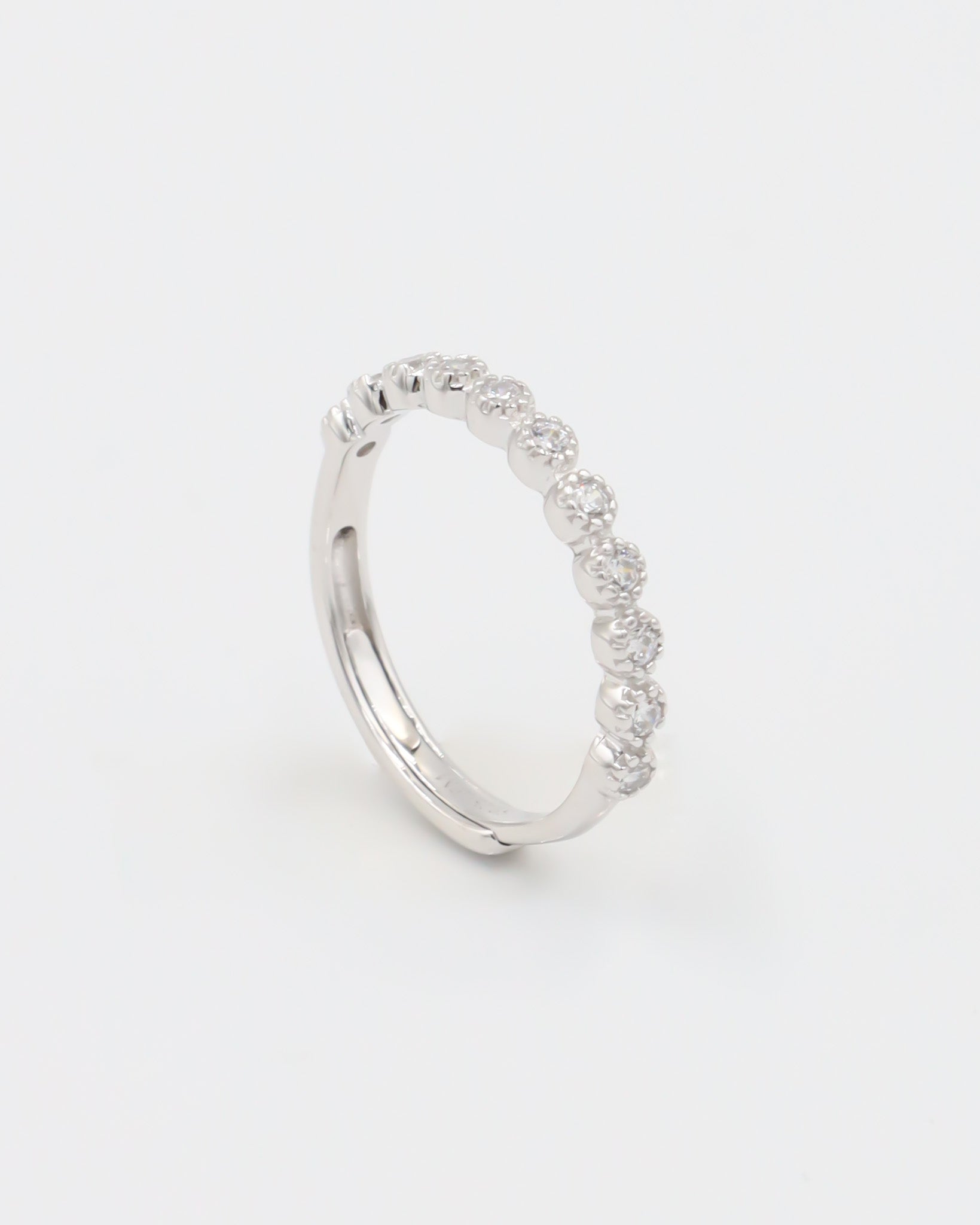 A silver ring with multiple stones set around its circumference.