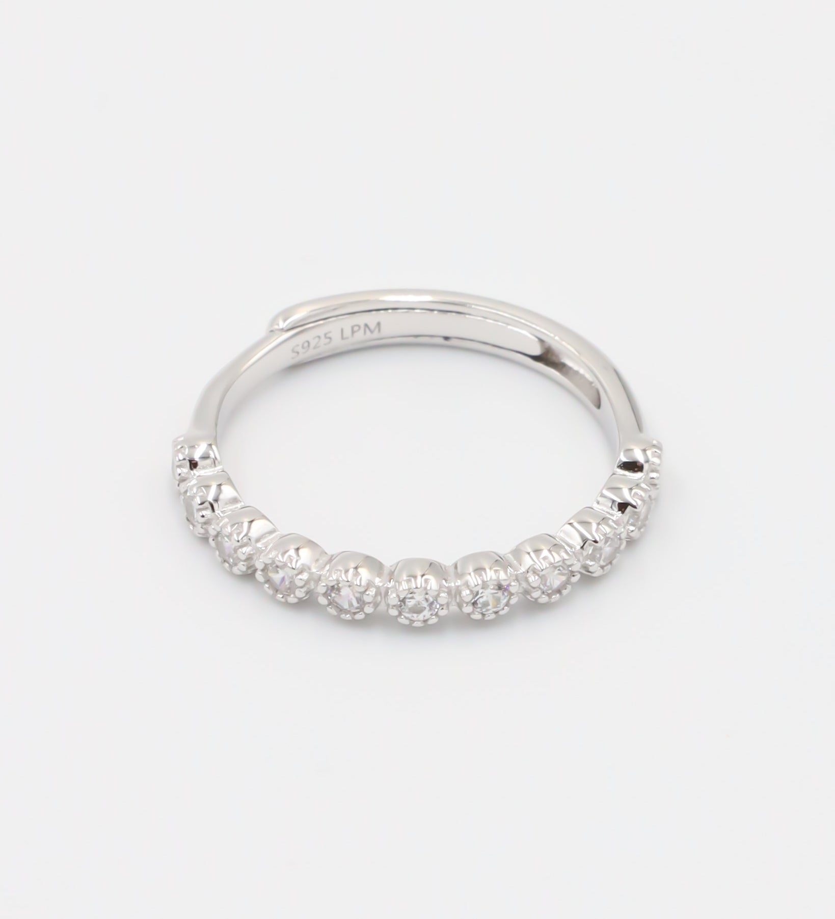 A silver ring with multiple stones set around its circumference.