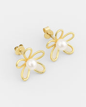 Gold flower-shaped earrings with pearl centers on a light gray background