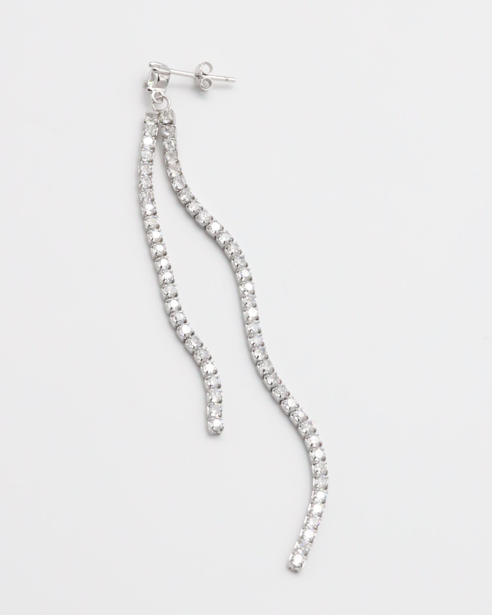 Silver earring with dangling crystal embellishments.