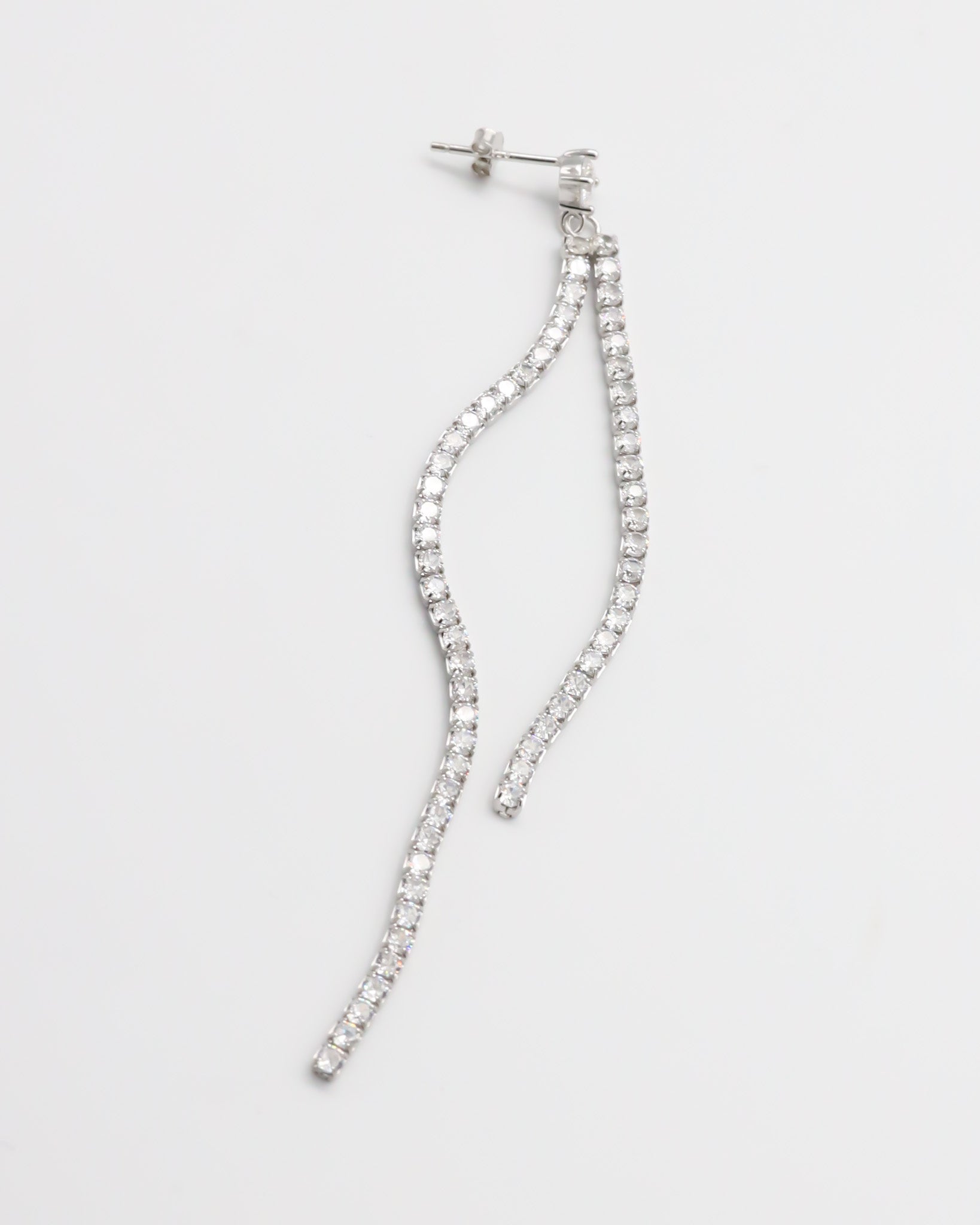Silver earring with dangling crystal embellishments.