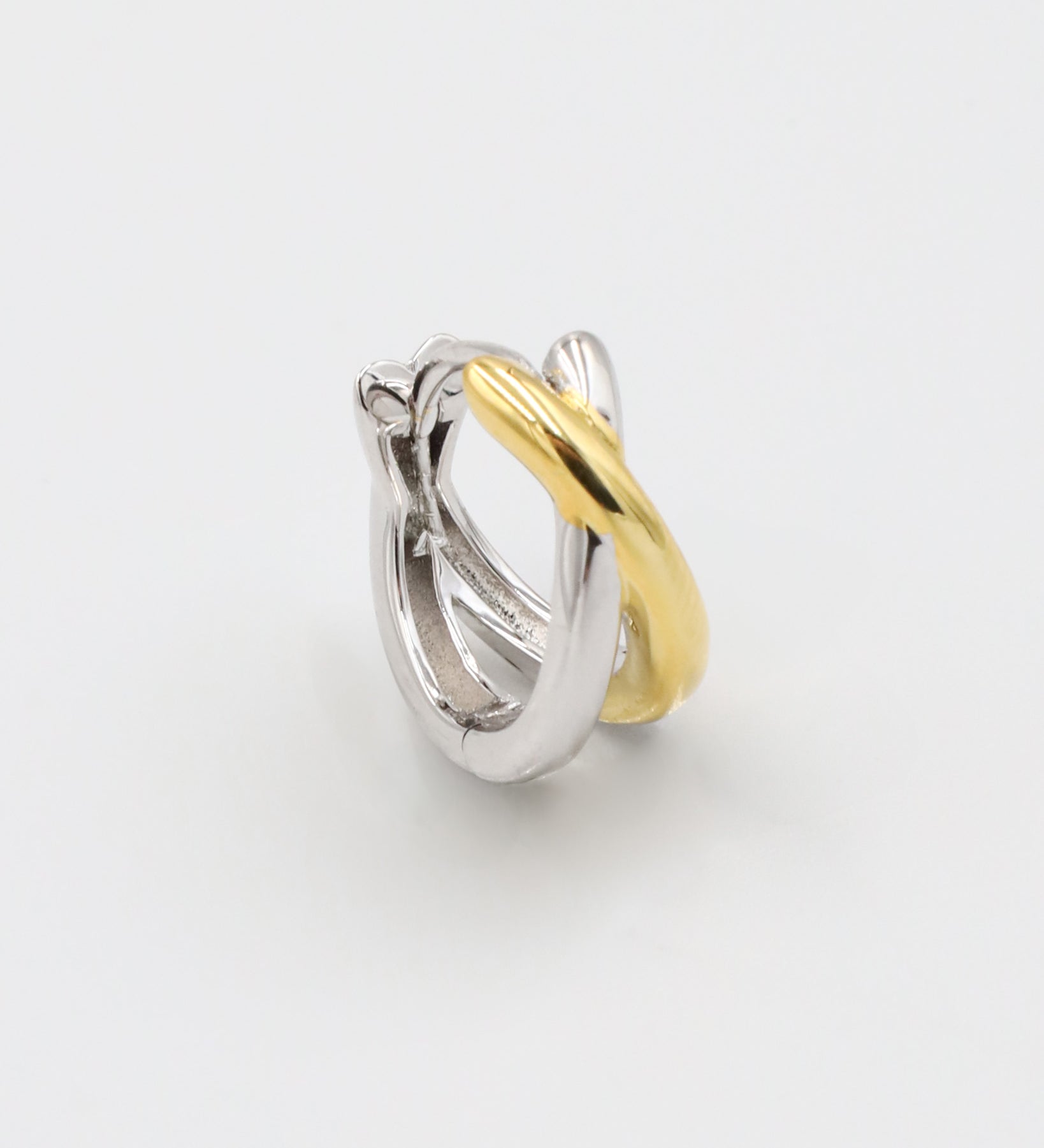 A single bicolor hoop earring with a hinged clasp, featuring mixed metals design, predominantly silver with gold accents.