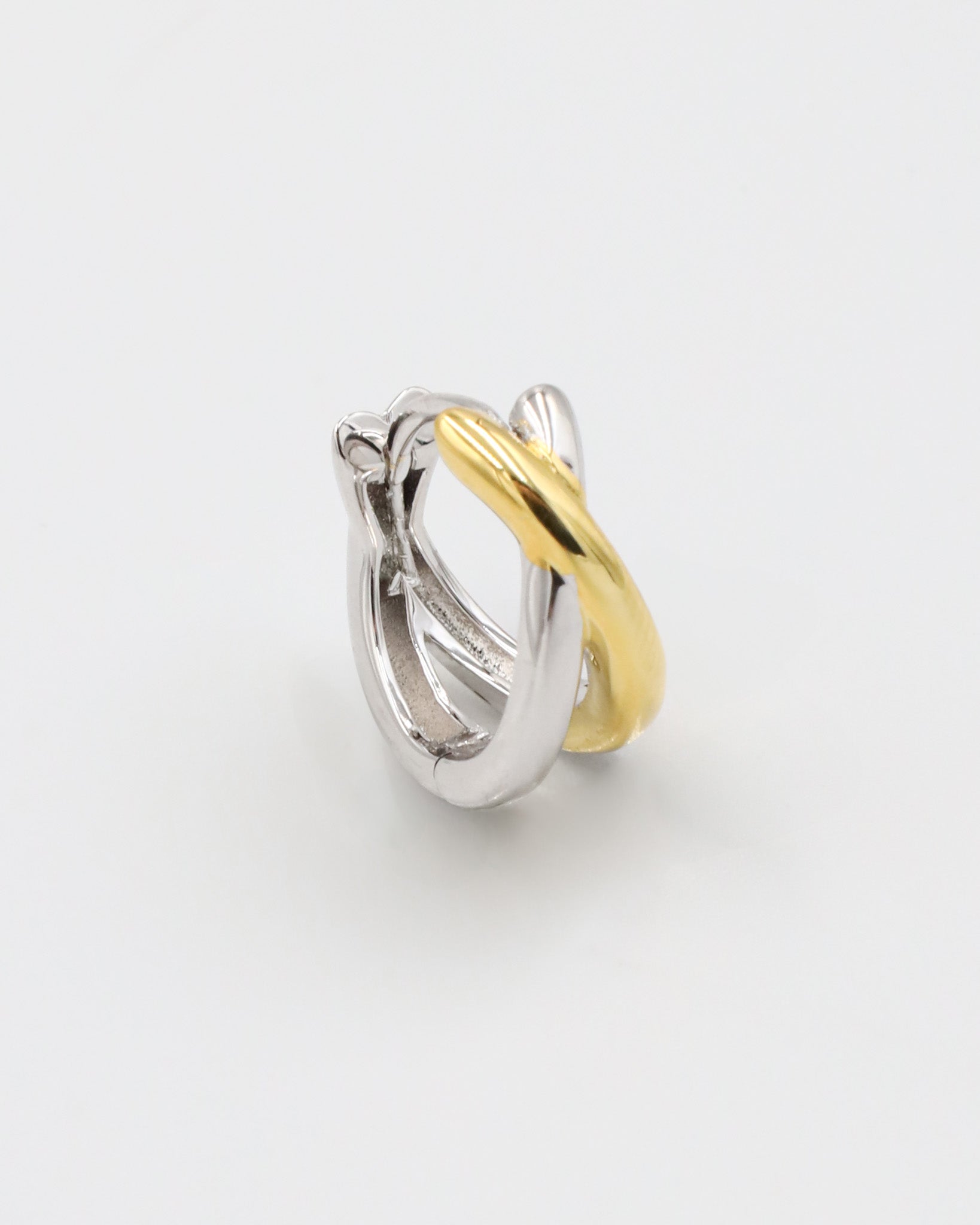 A single bicolor hoop earring with a hinged clasp, featuring mixed metals design, predominantly silver with gold accents.