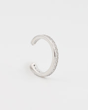 Silver ear cuff with small stones on a light gray background