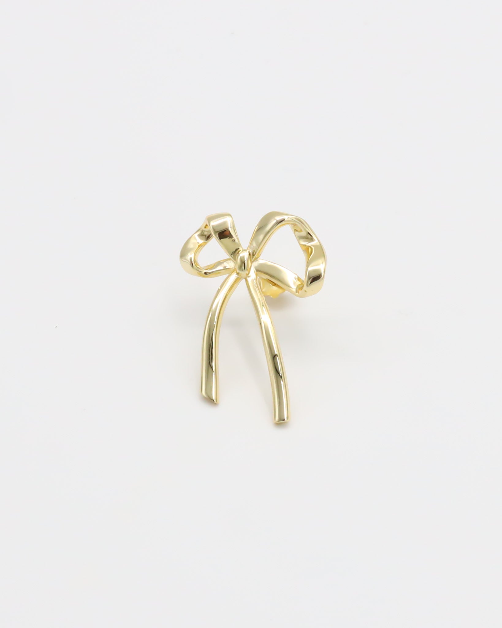A single gold bow-shaped earring on a white background