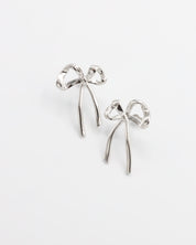 A pair of silver bow-shaped earrings on a white background