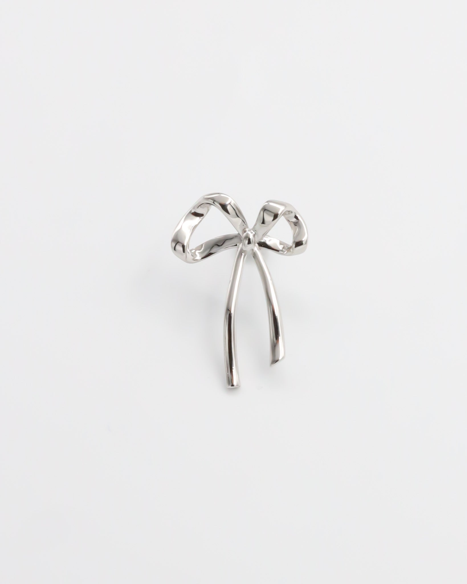 A single silver bow-shaped earring on a white background