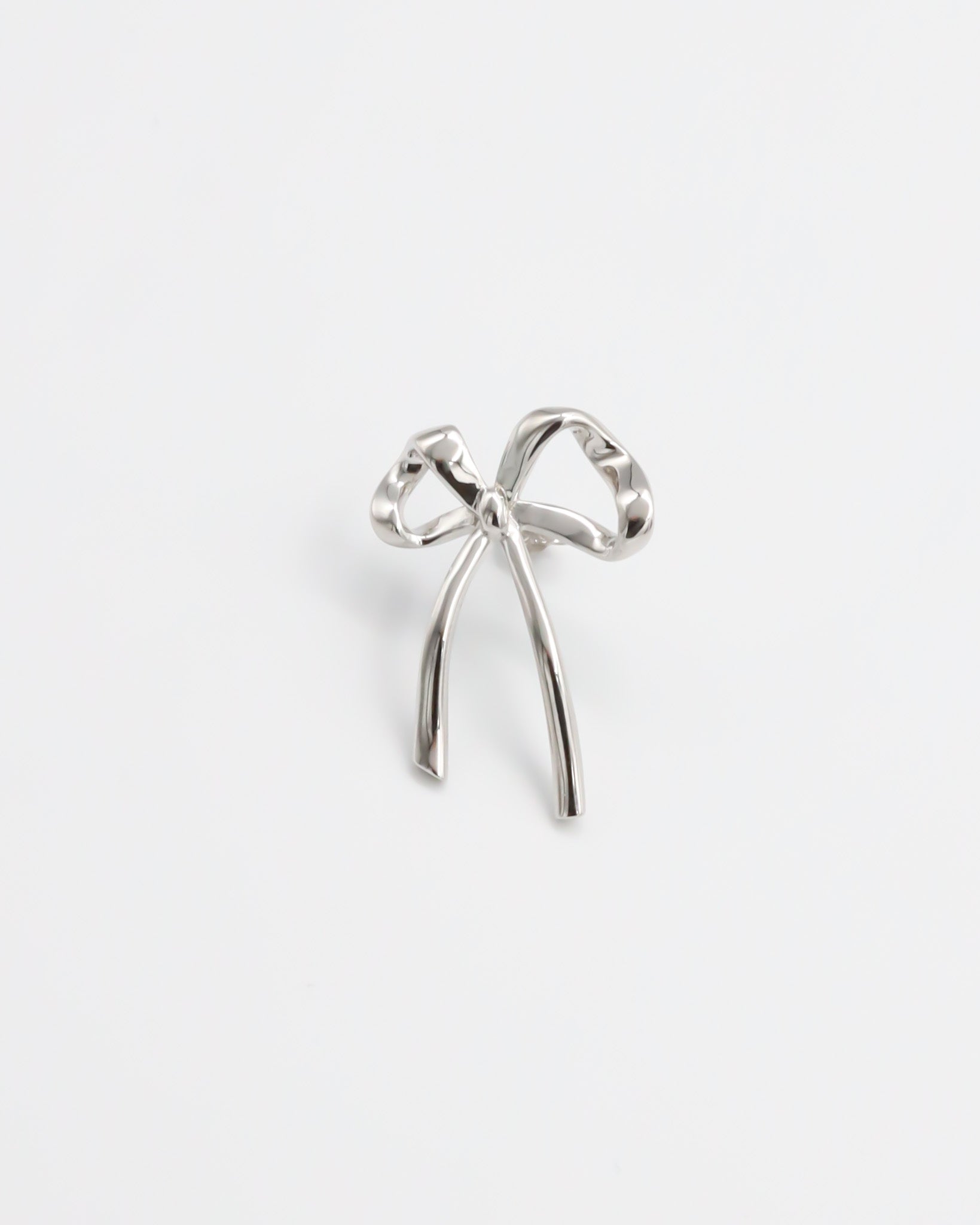 A single silver bow-shaped earring on a white background