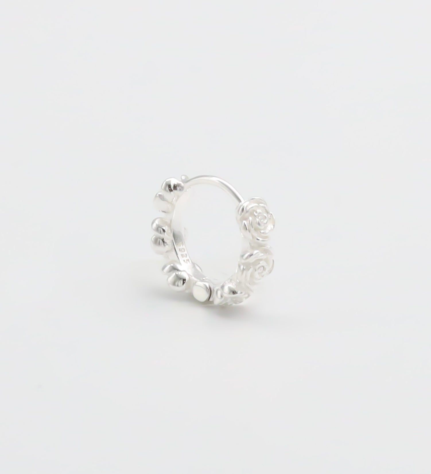 A silver hoop earring with a textured surface on a white background.