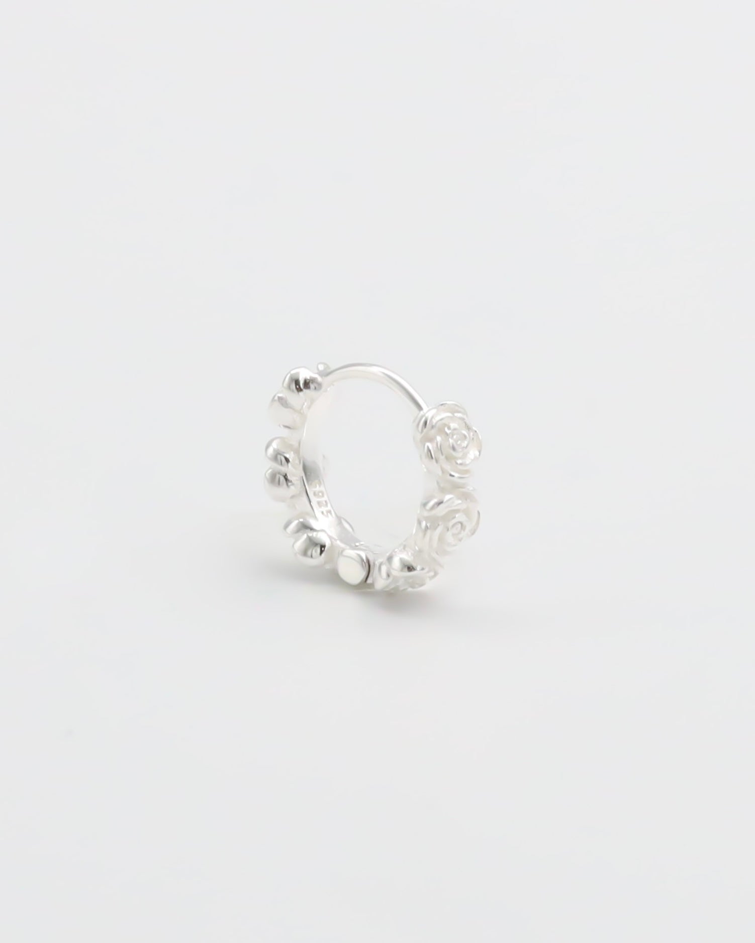 A silver hoop earring with a textured surface on a white background.